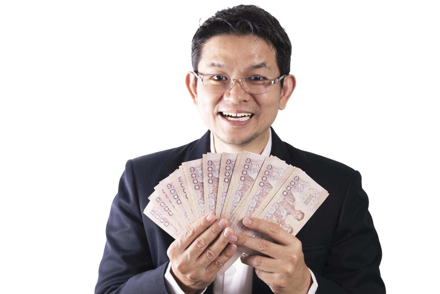 hombre de negocios tailandés feliz sosteniendo dinero en billetes de baht tailandés - personas con concepto de éxito empresarial foto