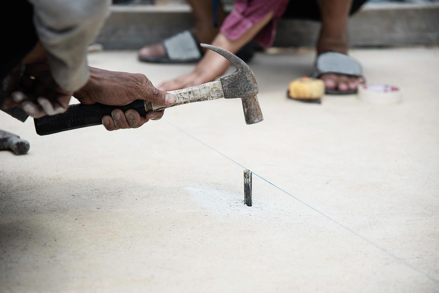 Workman is setting level for concrete floor pouring - man working in construction site concept photo