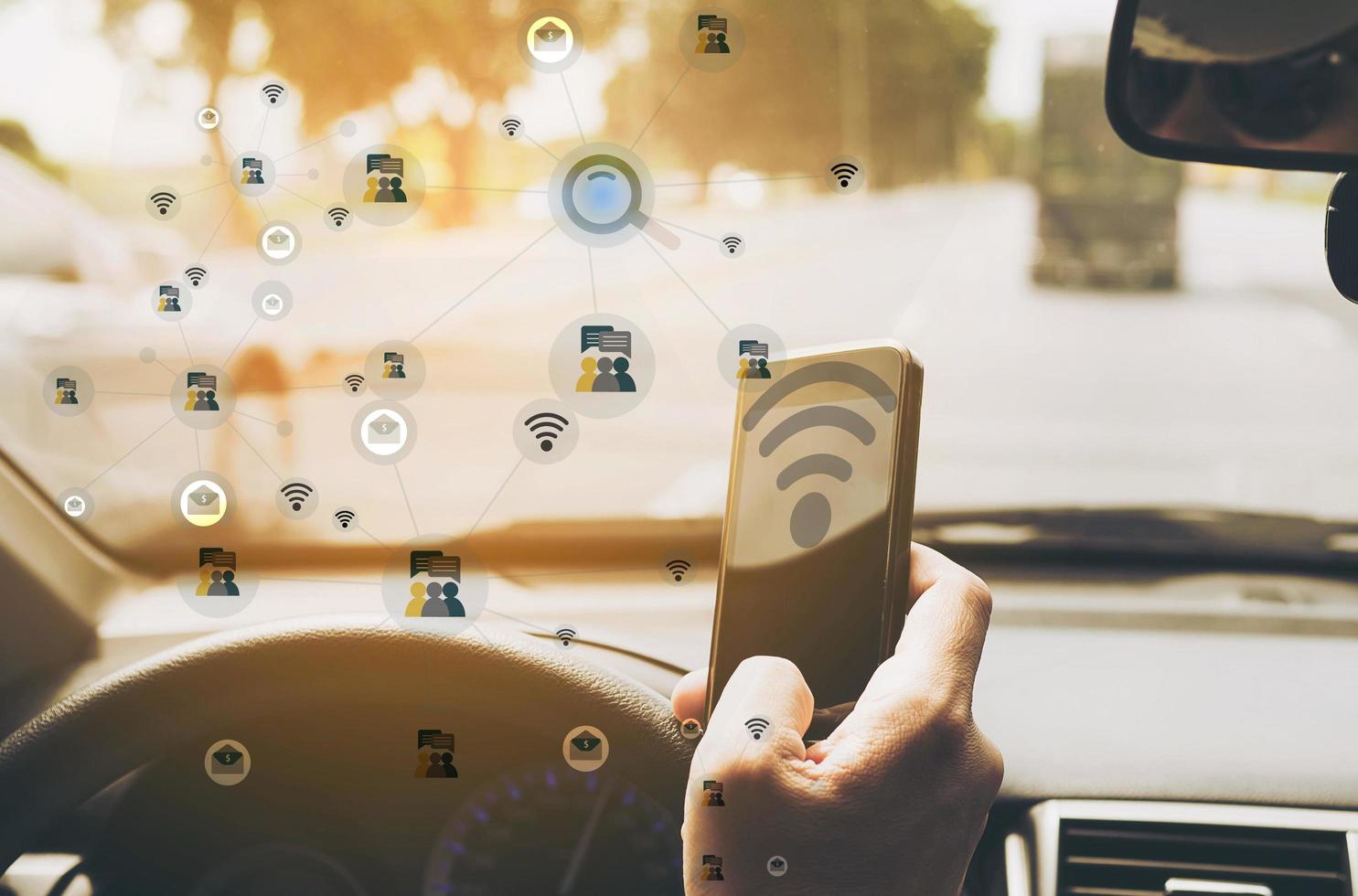 Man using mobile phone while driving car with network icons overlay, internet of thing - IOT concept photo