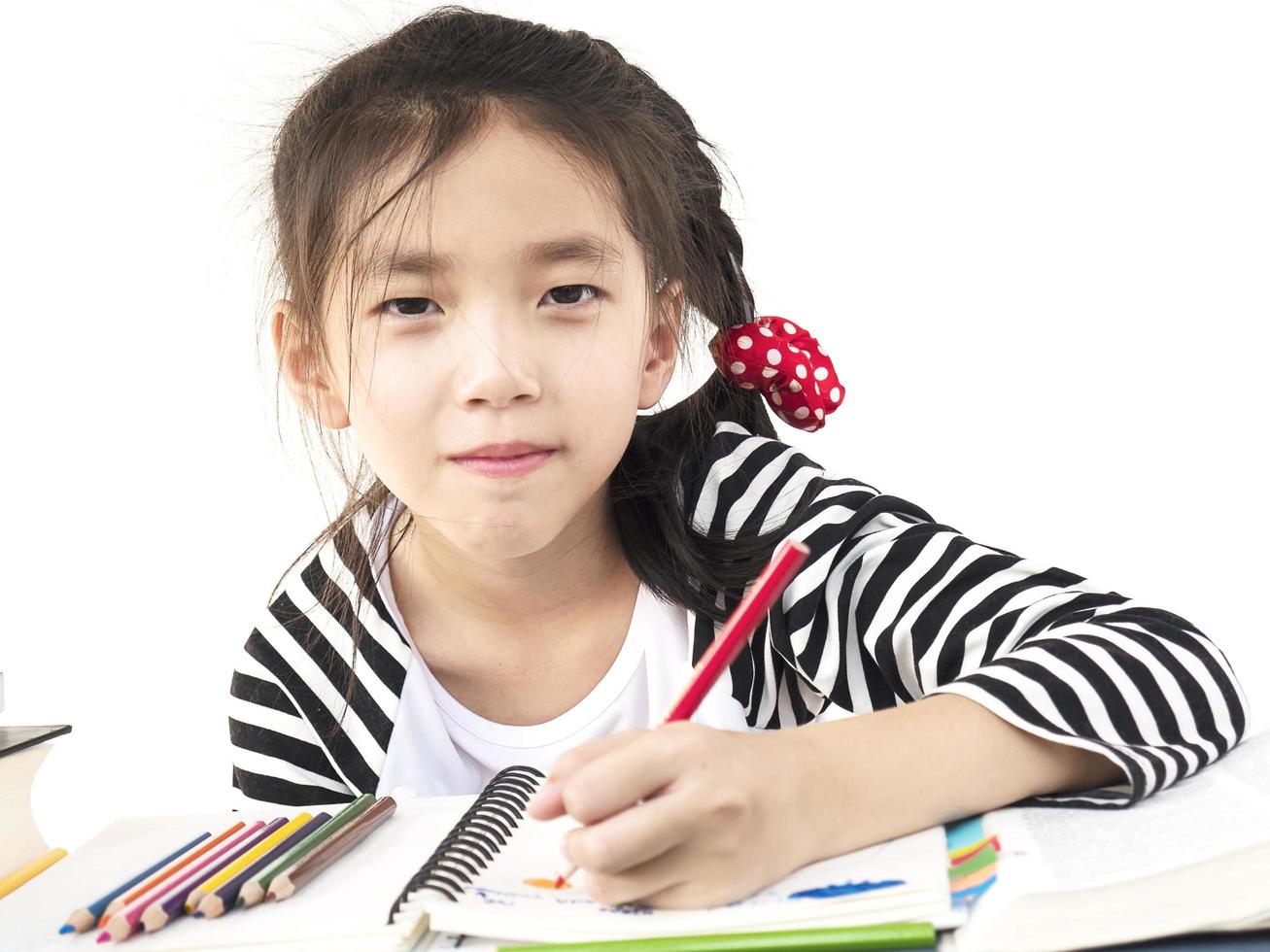 A lovely girl is doing homework, coloring or drawing a book photo