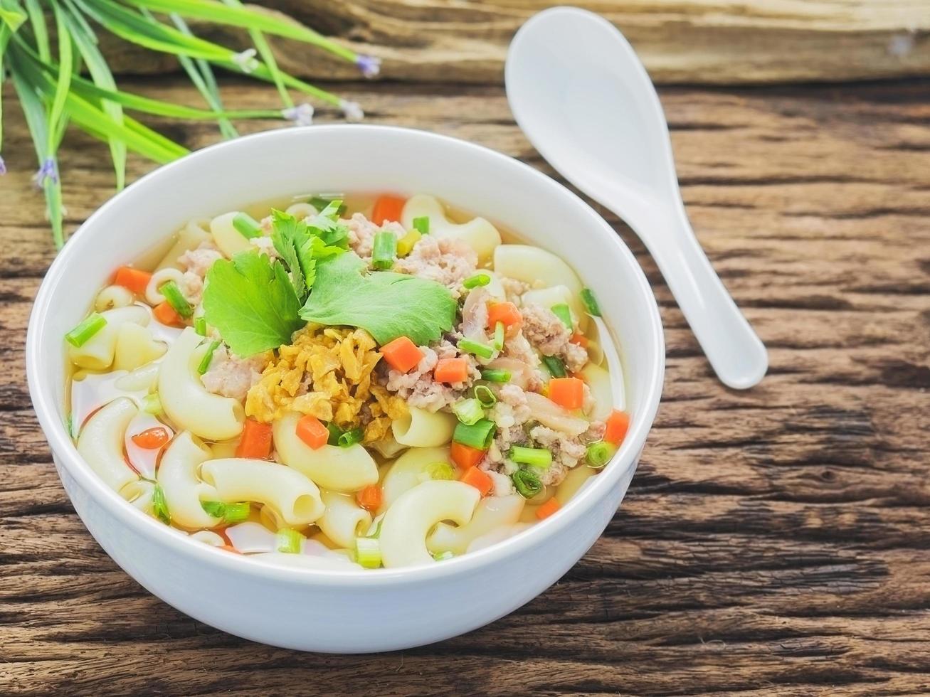 Macaroni soup putting on sack cloth and wooden background photo