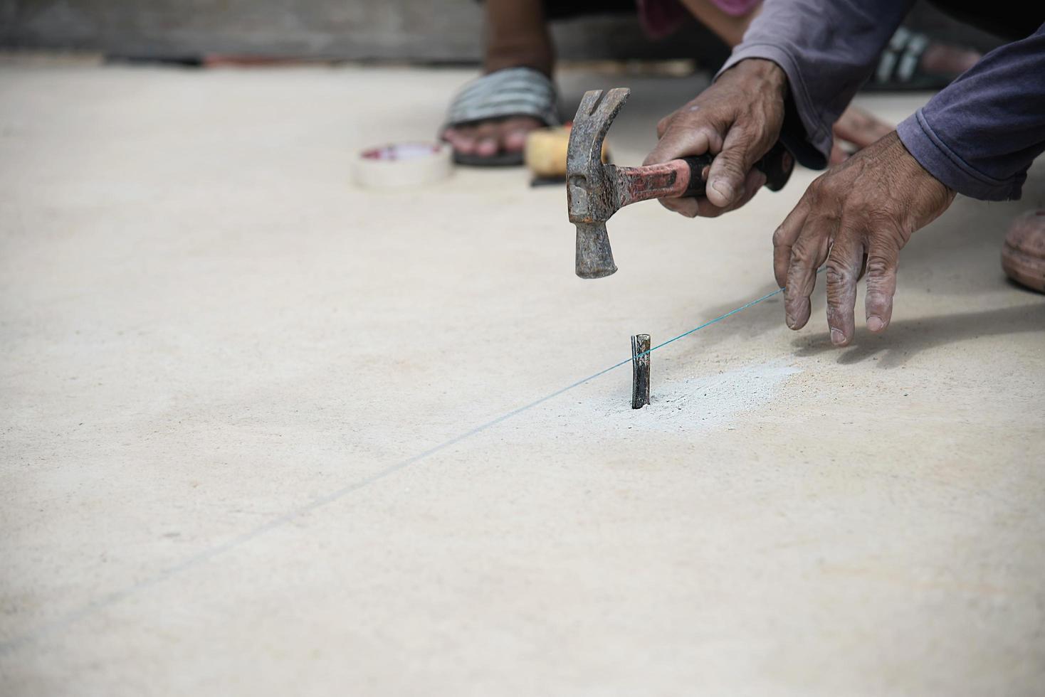 Workman is setting level for concrete floor pouring - man working in construction site concept photo