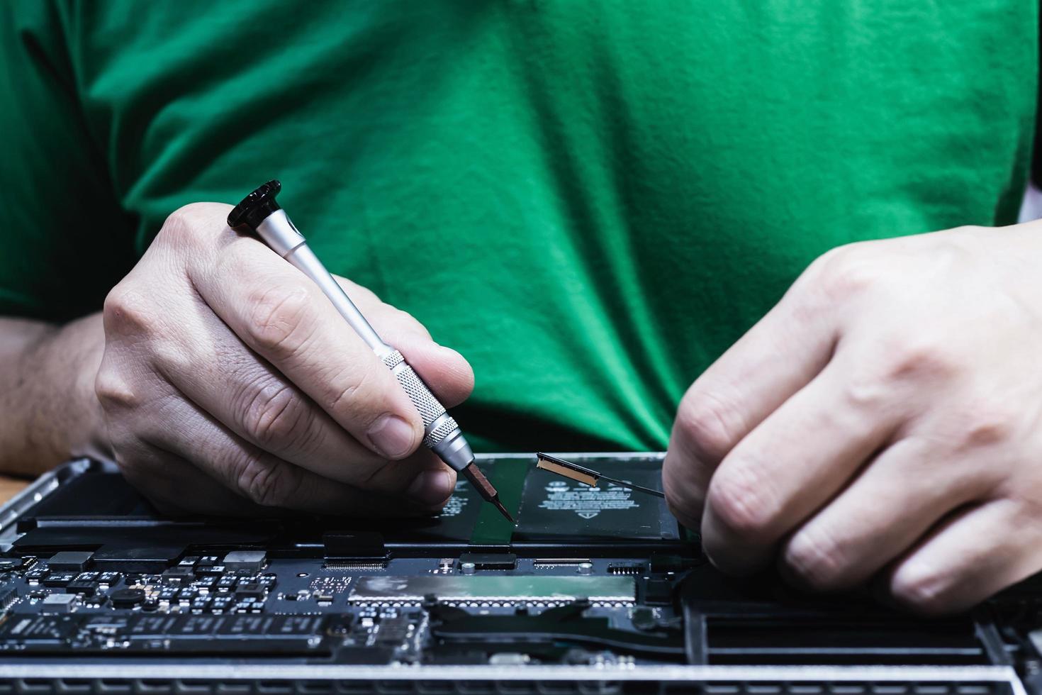 Man fixing laptop computer - technology computer reparing concept photo