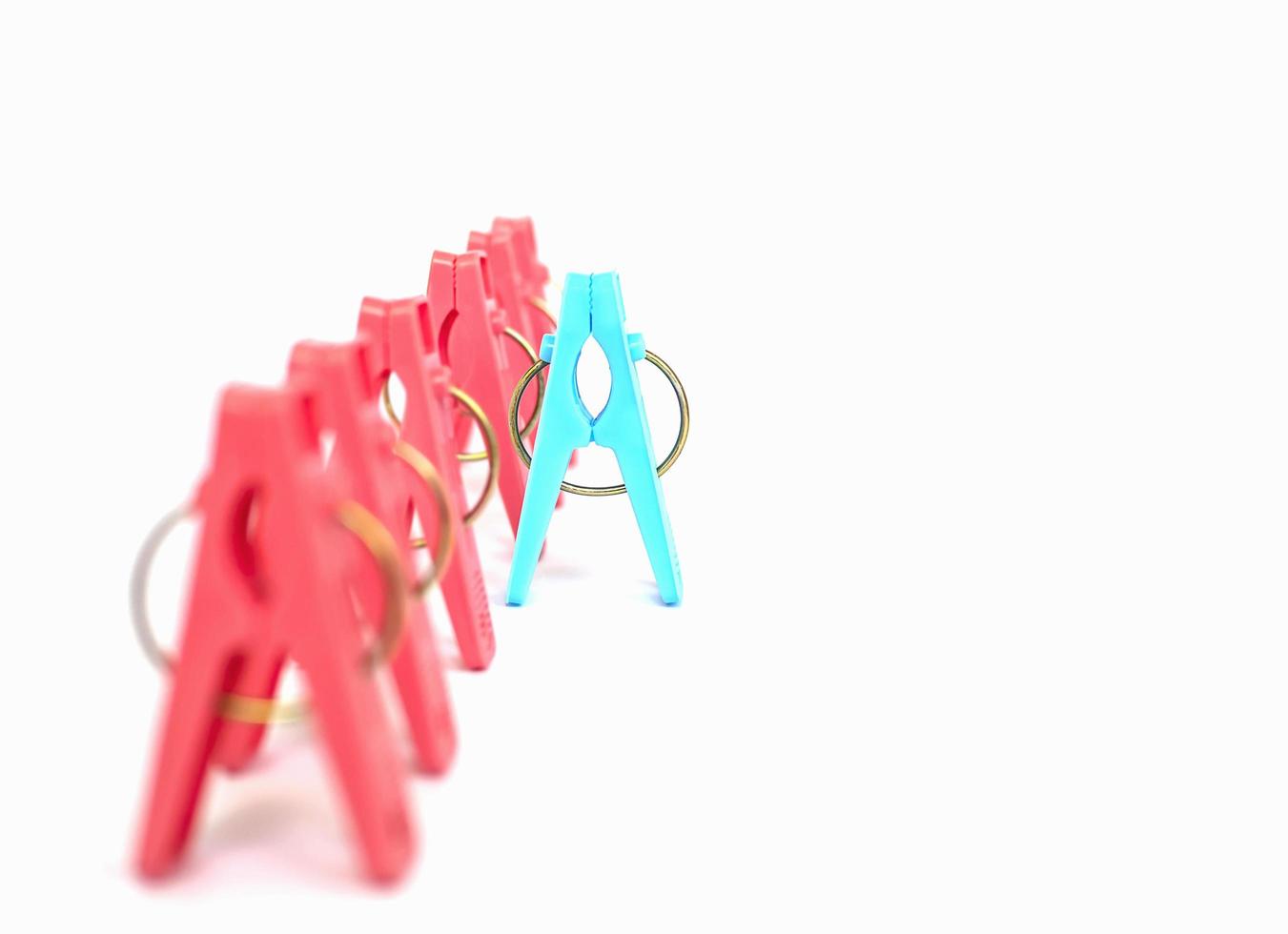 Different or competition concept using colorful plastic clothespins over white background photo