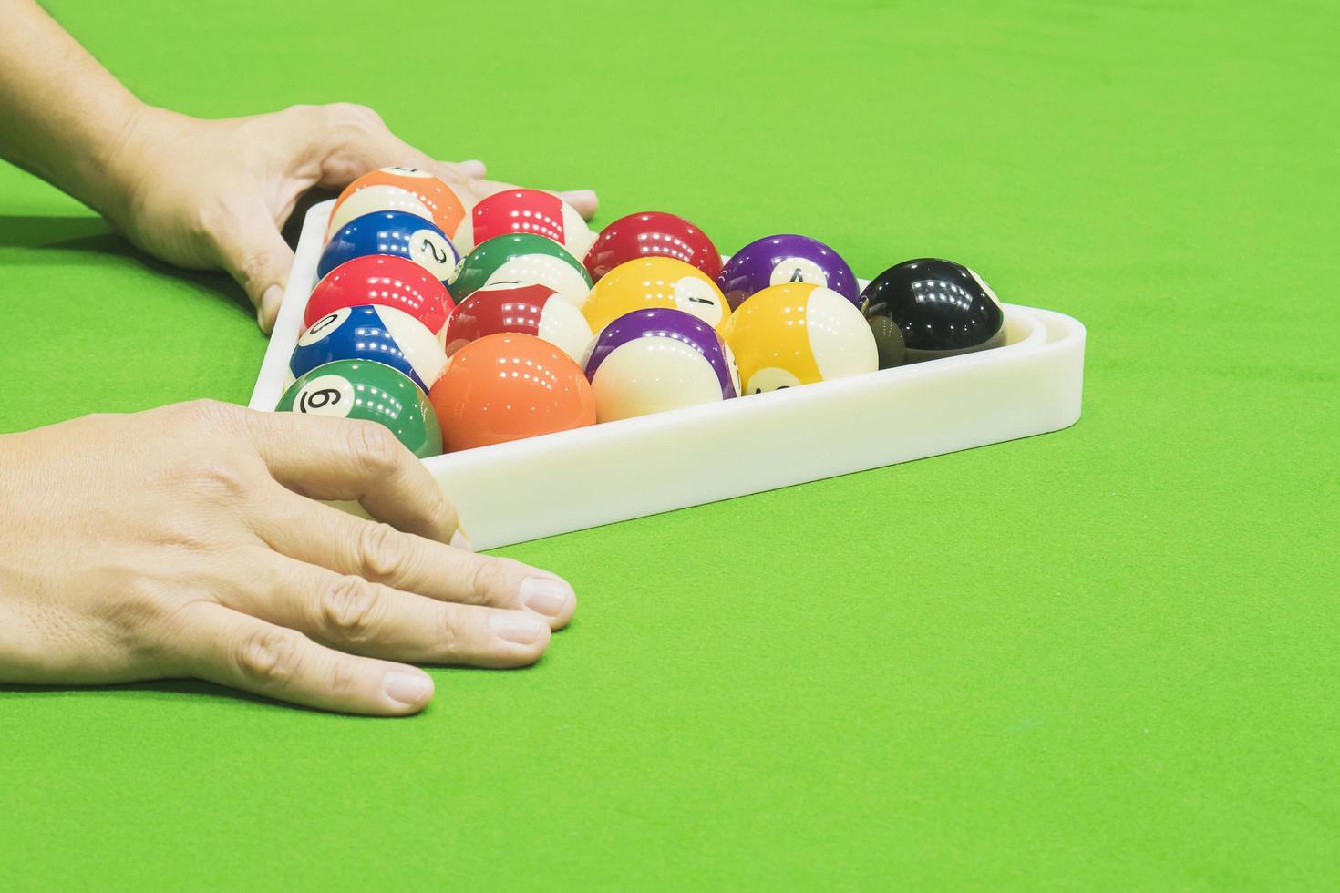 Man setting pool ball for snooker table before starting new game photo