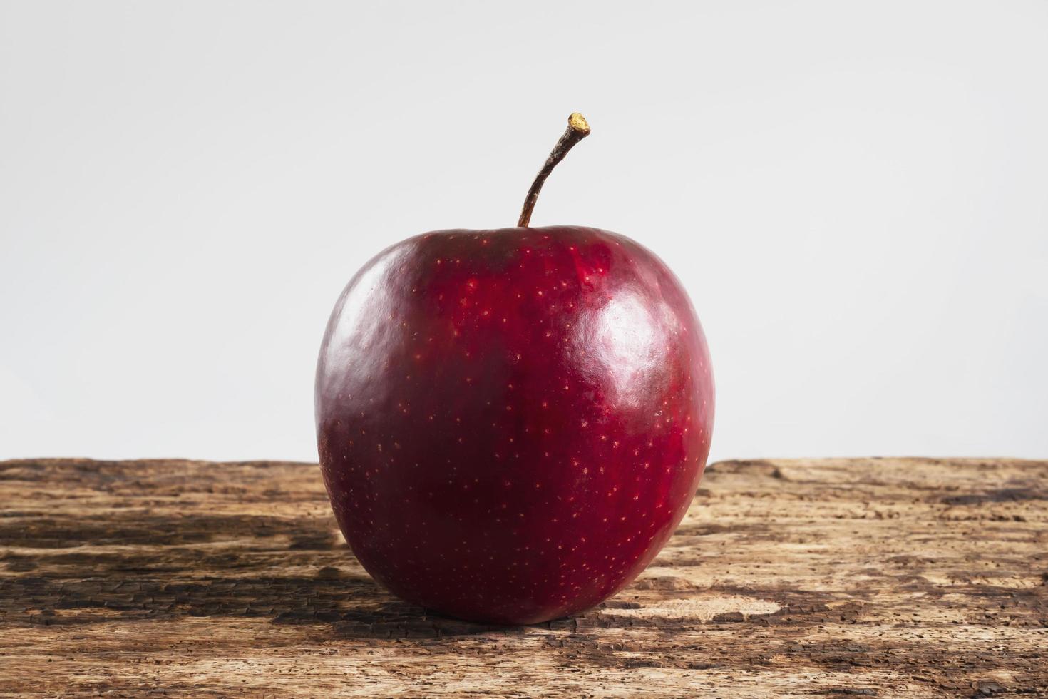 Fresh red apple over old wooden texture background - fresh fruit background concept photo