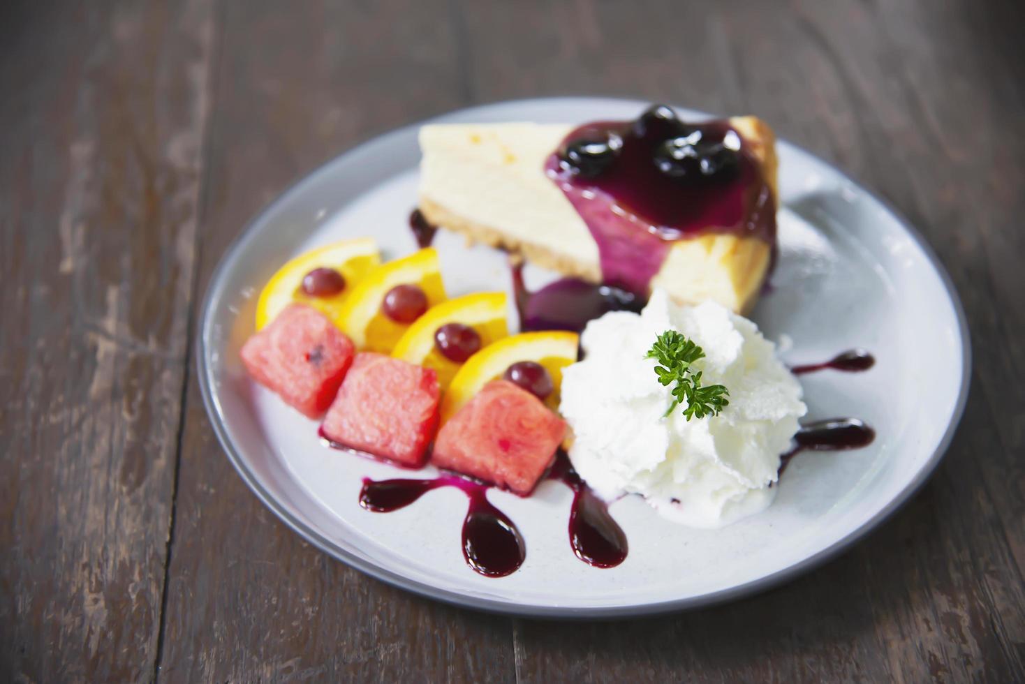 Colorful New York cheese cake with well decorated fruit pieces and whipped cream in white plate - cake recipe menu concept photo