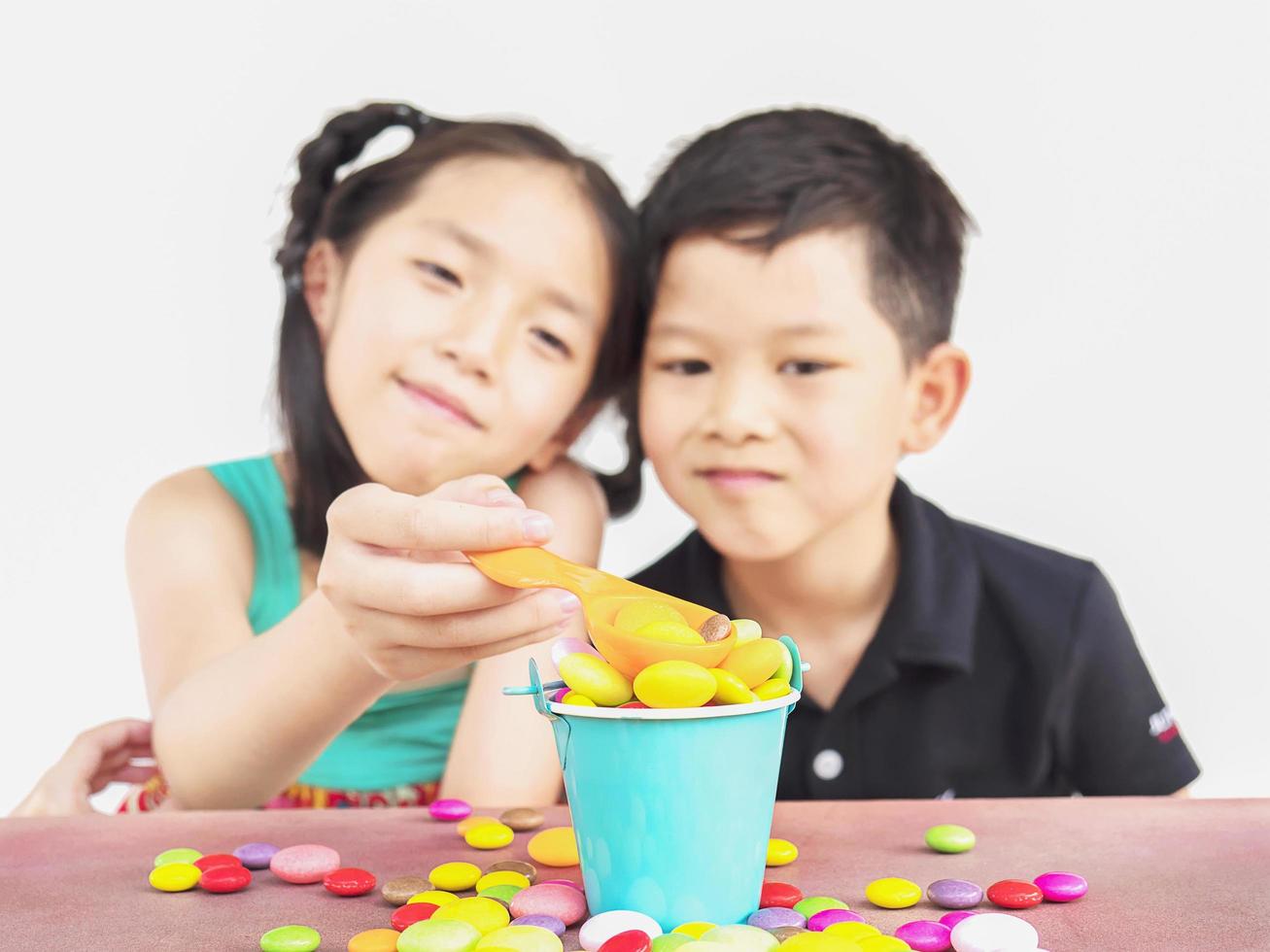 Asian kids are playing with candy. Photo is focused at candy.