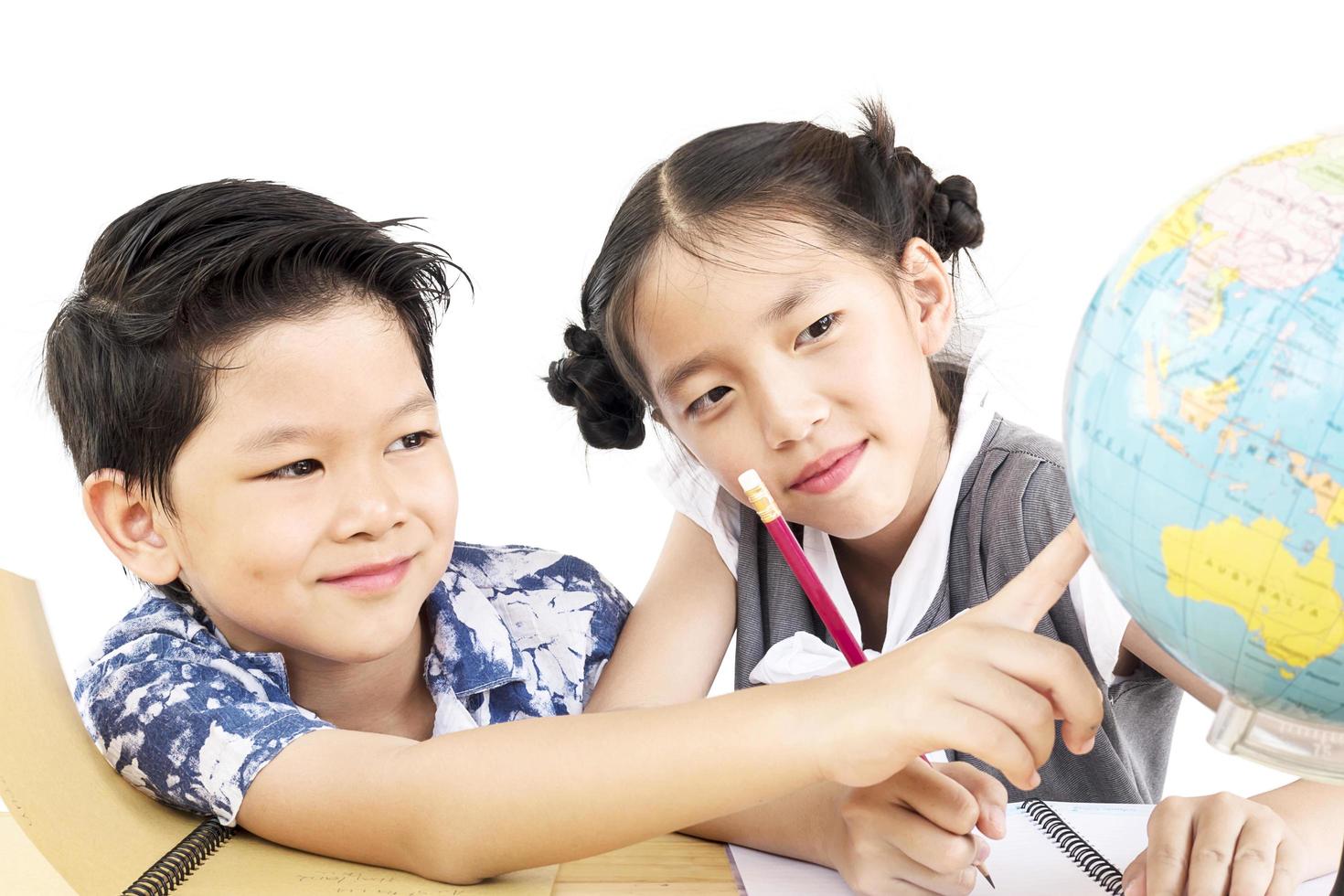 Asian kids are studying the globe over white background photo