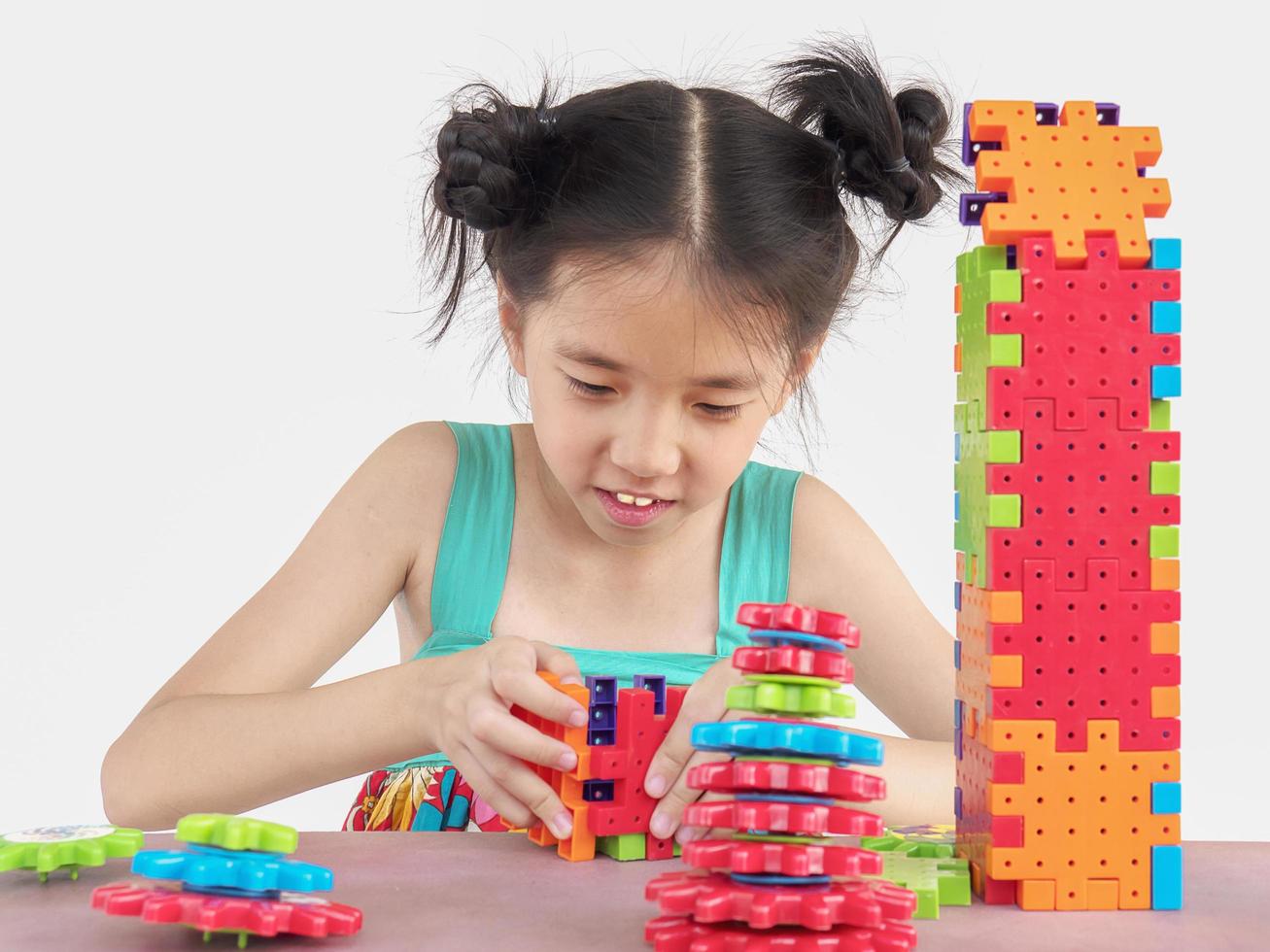 Asian child is playing puzzle plastic block creative game to practice their physical and mental skill photo