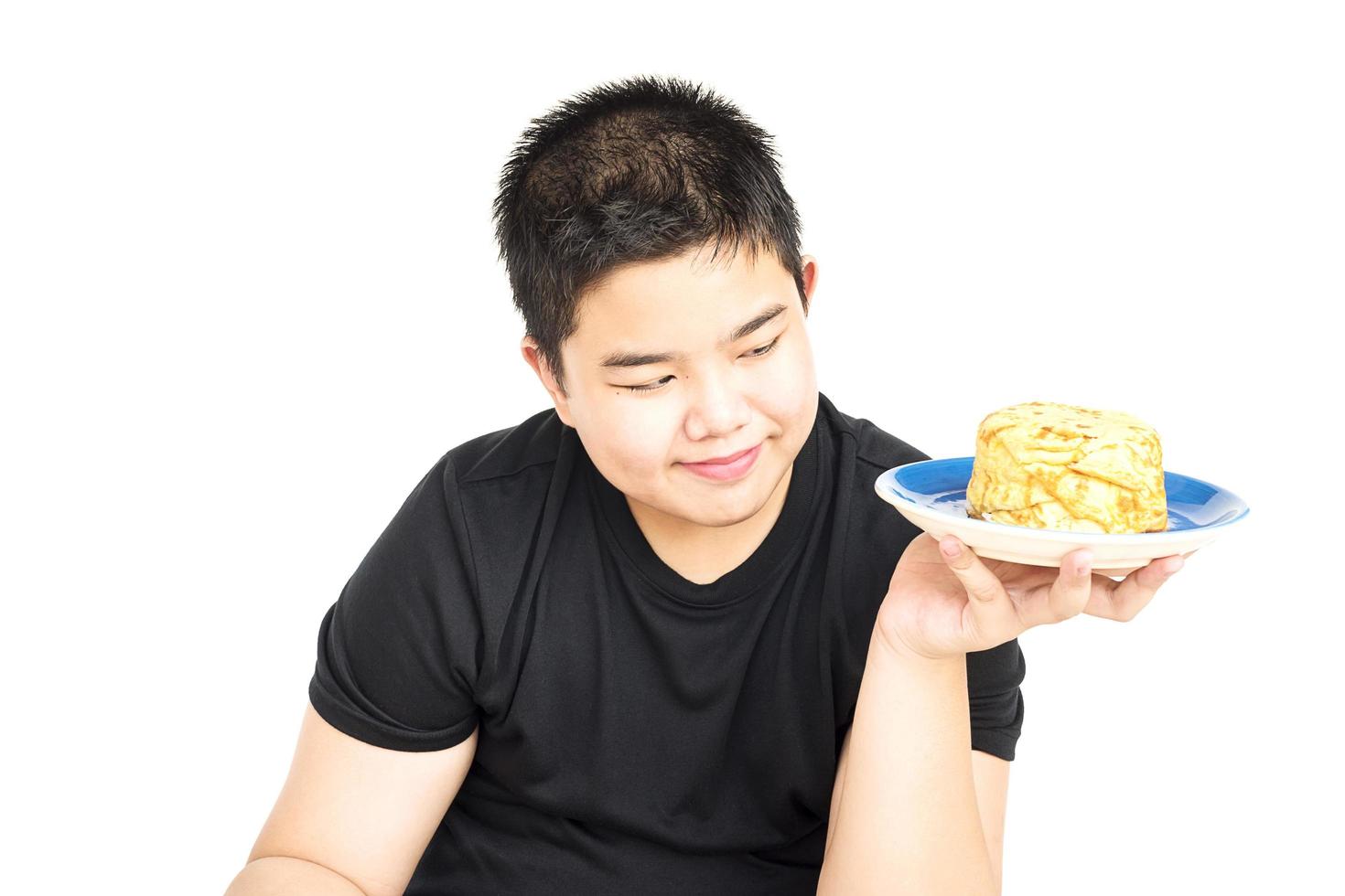 Los niños asiáticos de 14 años muestran felizmente su arroz con tortilla frita aislado sobre blanco foto