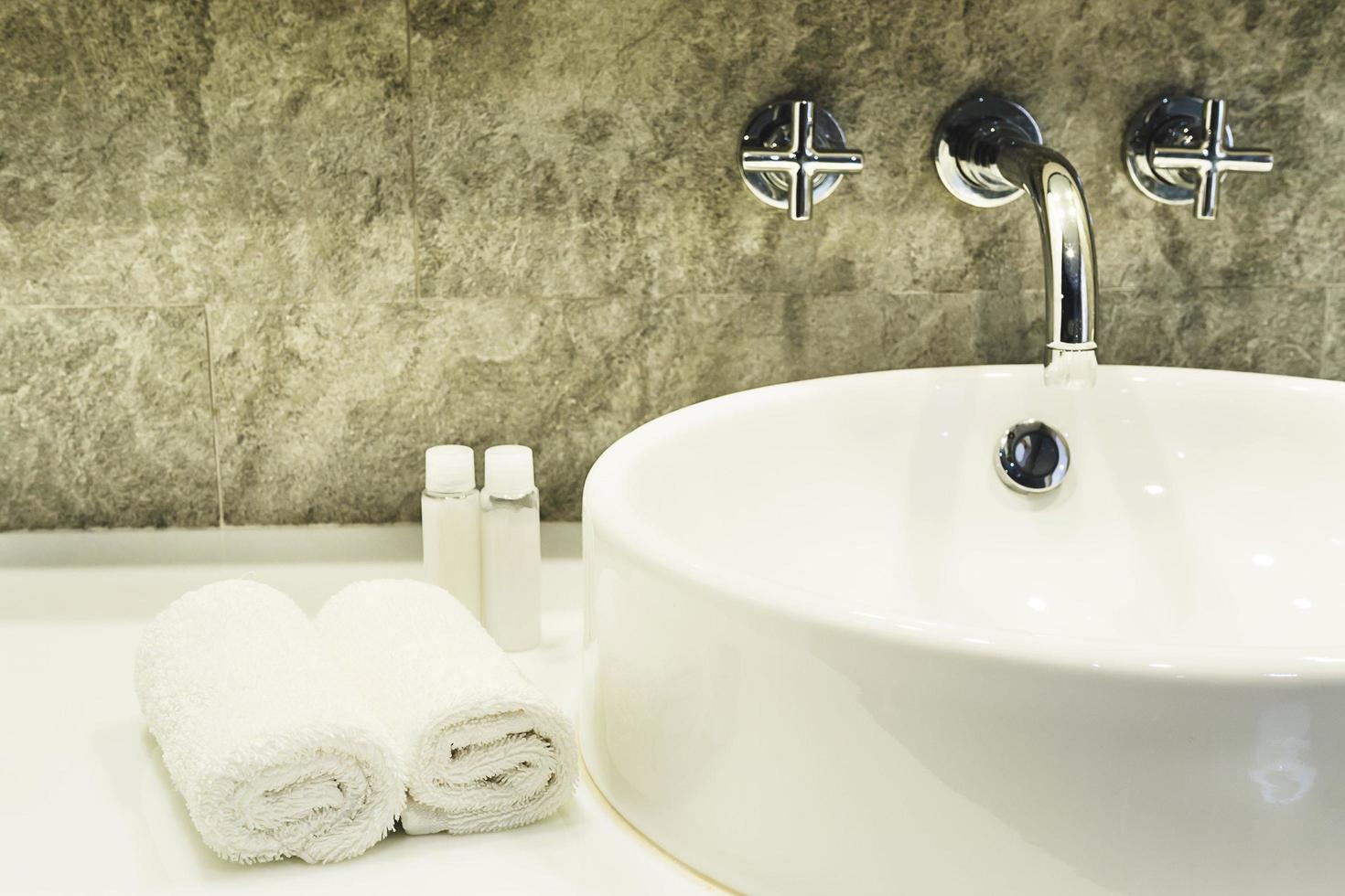 lavabo de baño con juego de limpieza blanco en un hotel foto