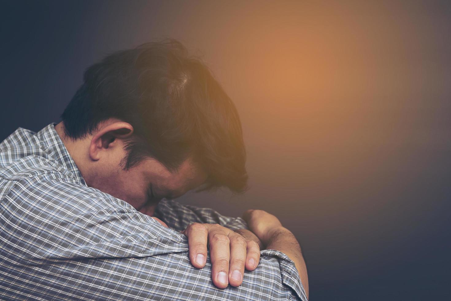 Sad man holding head with hand photo