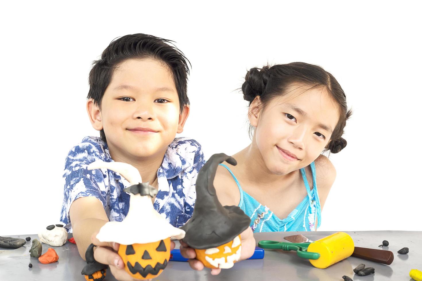 niño y niña juegan felizmente a un juguete de arcilla foto