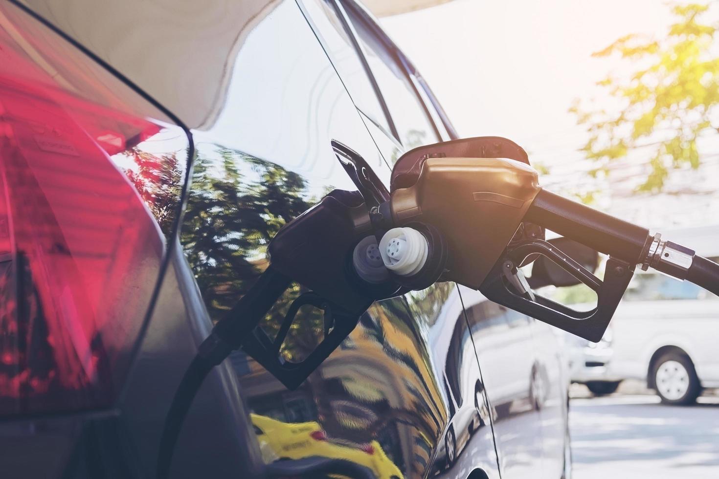 Refueling car tank with gasoline nozzle head photo