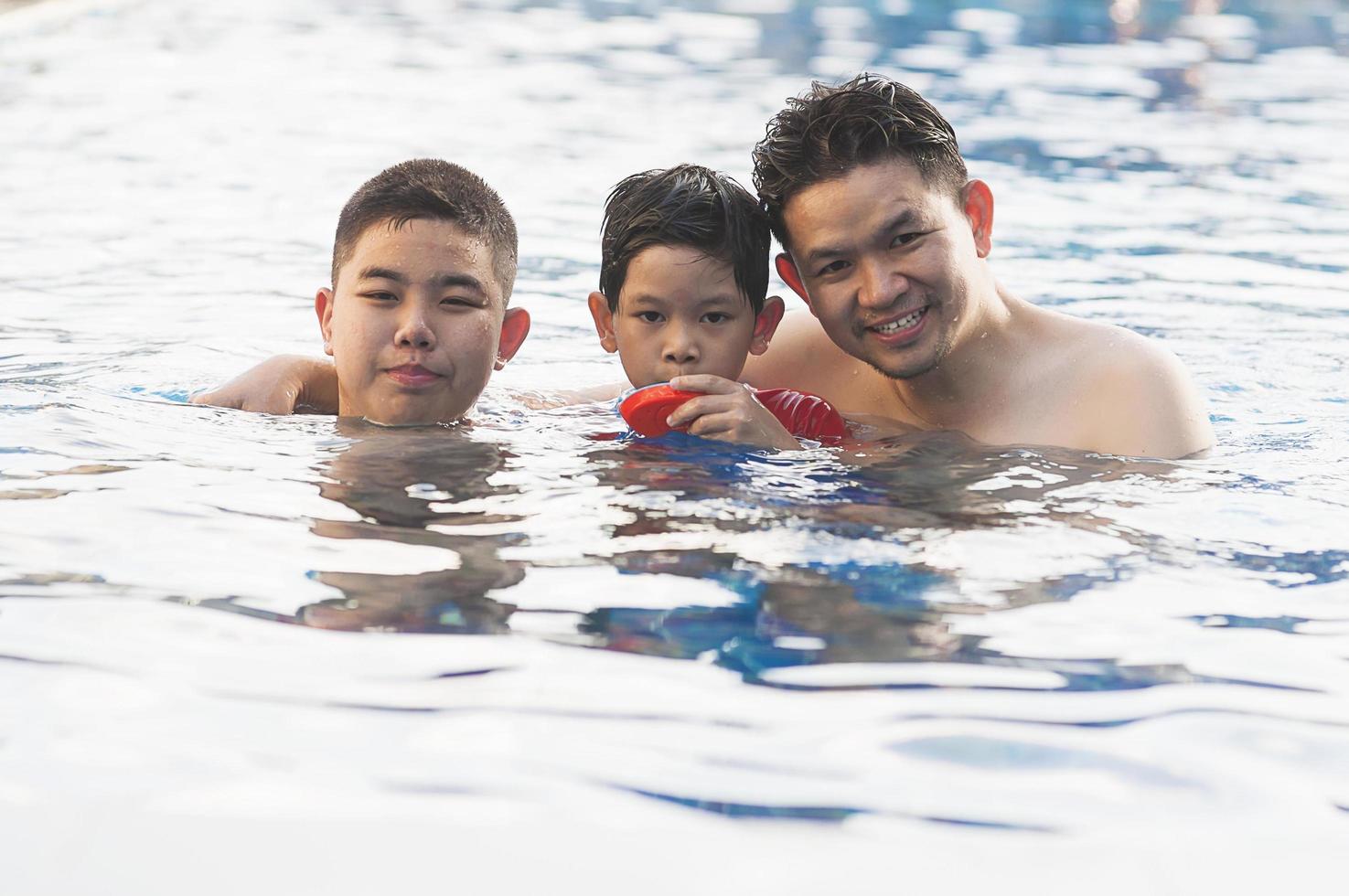 Happy dad and son swimming in a pool photo
