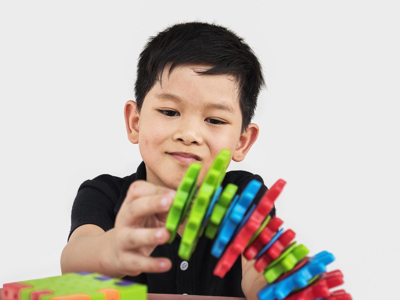 Asian children are playing puzzle plastic block creative game to practice their physical and mental skill photo