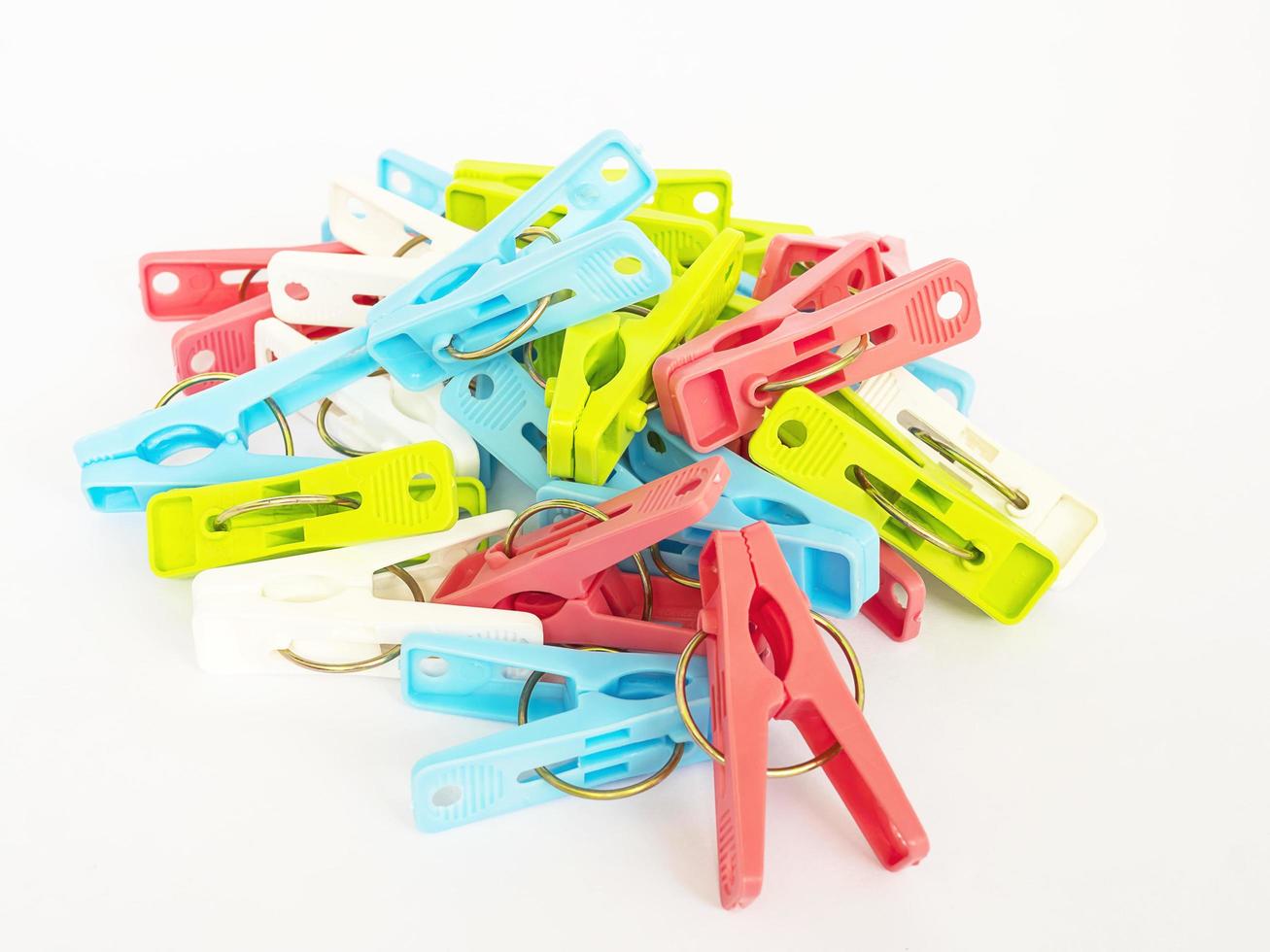 Colorful plastic clothespins over white background photo