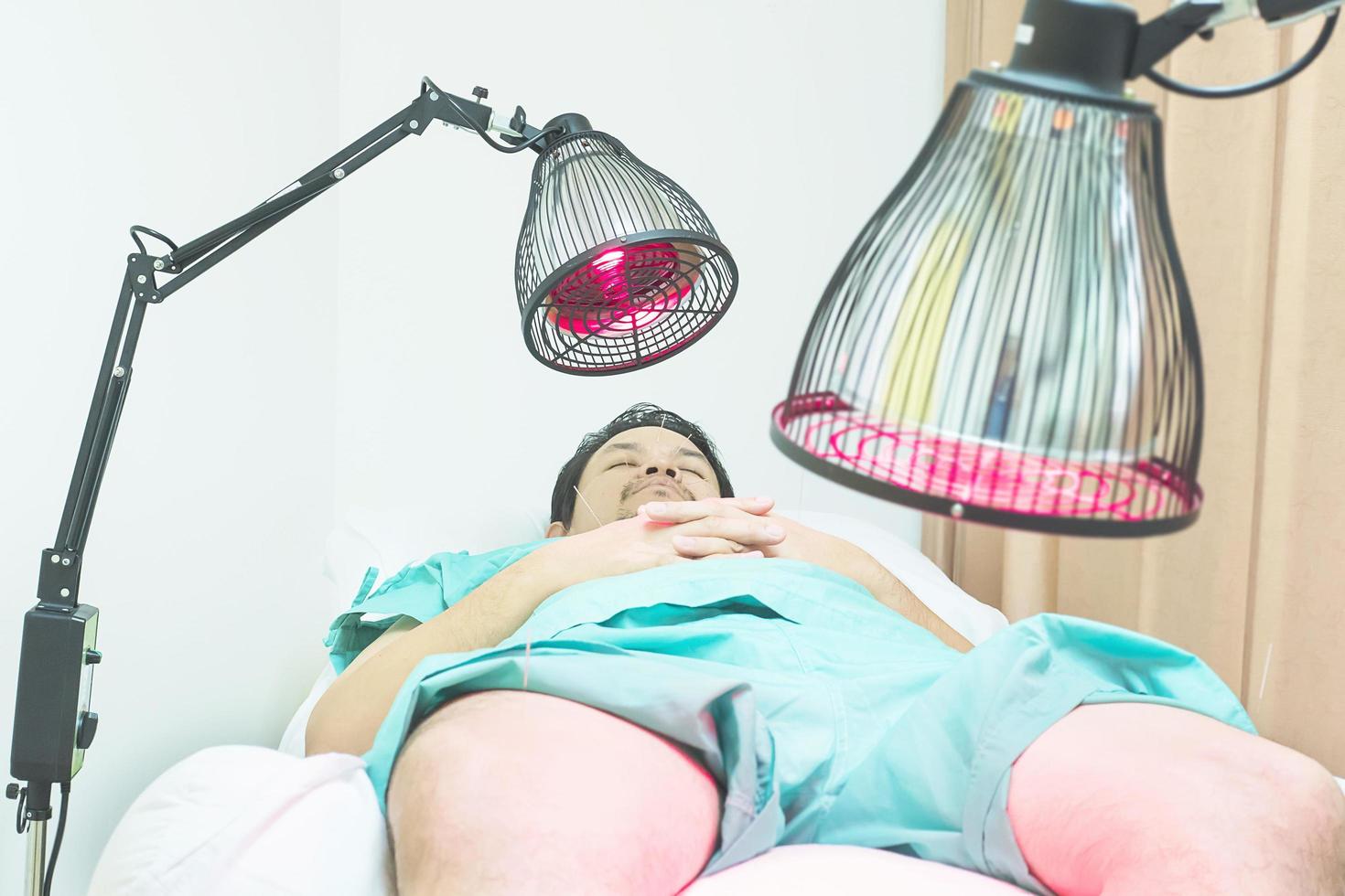 Asian man is receiving Acupuncture treatment. photo