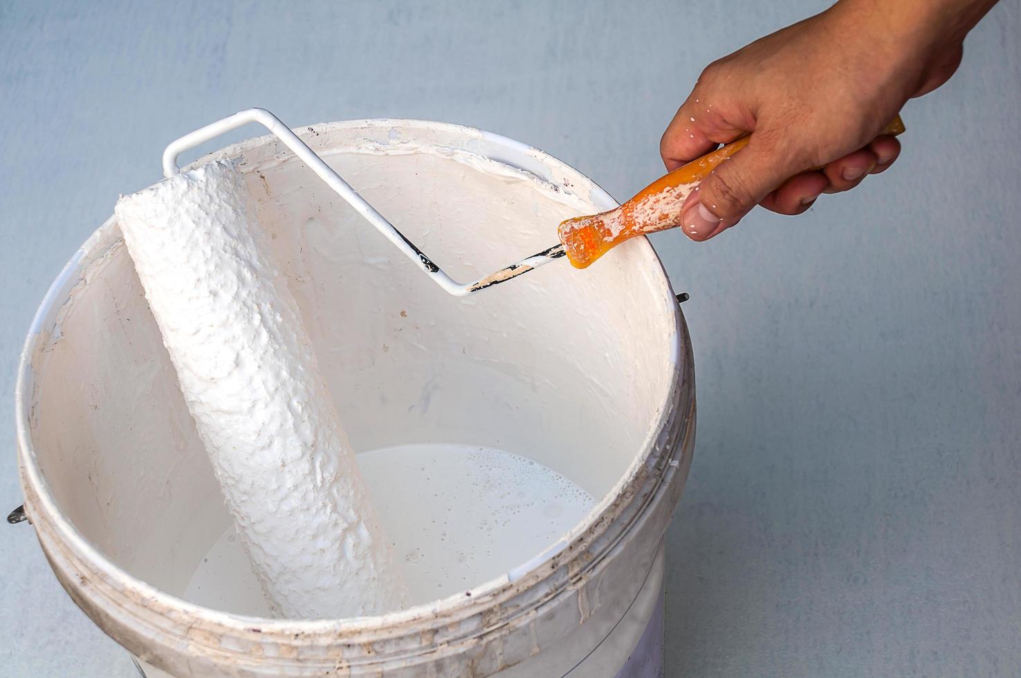 Hand holding rolling paint brush, ready to paint photo