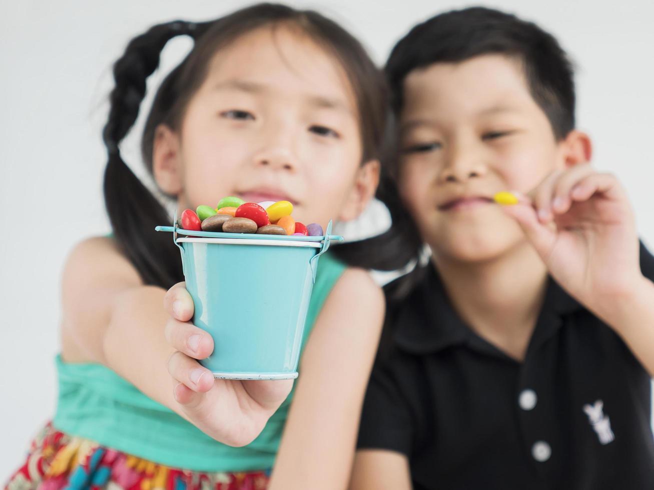 Asian kids are playing with candy. Photo is focused at candy.