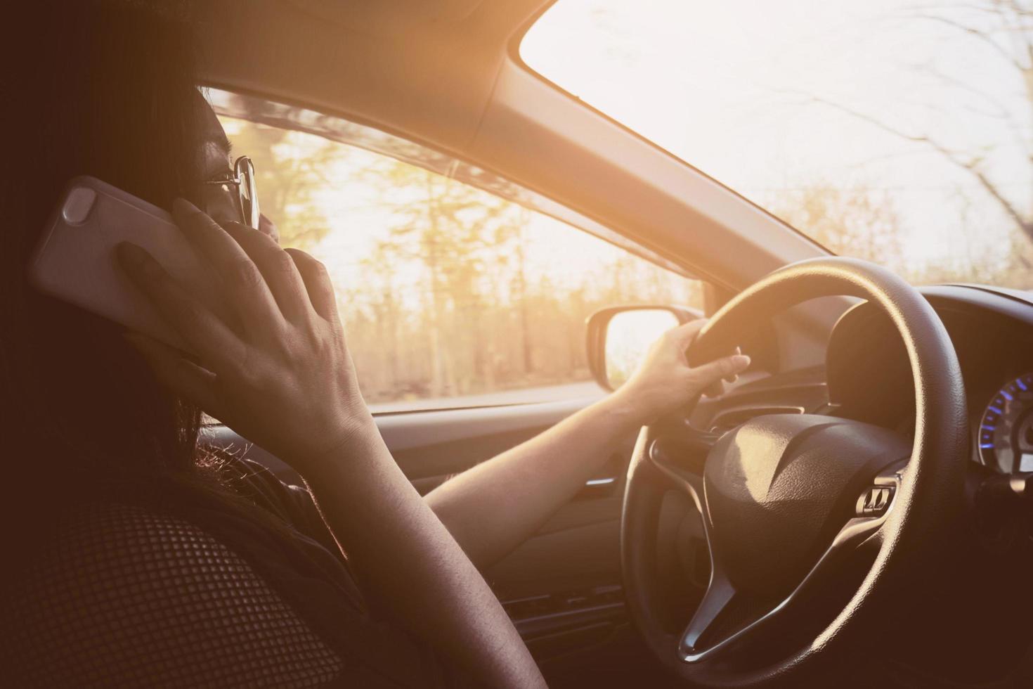Lady using mobile phone while driving car dangerously photo