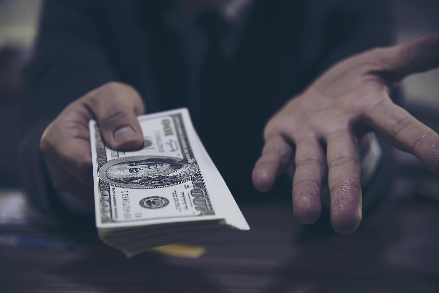 Bank teller man's hands giving dollar banknotes photo