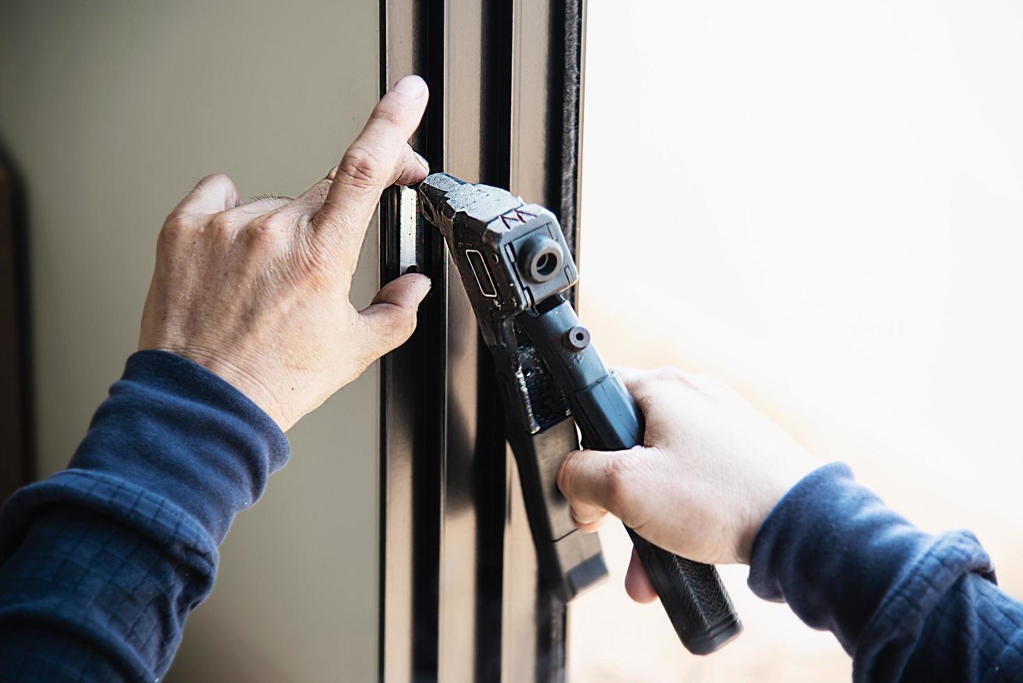 Man doing aluminum frame with glasses and wire screen door and window installation work in construction site photo