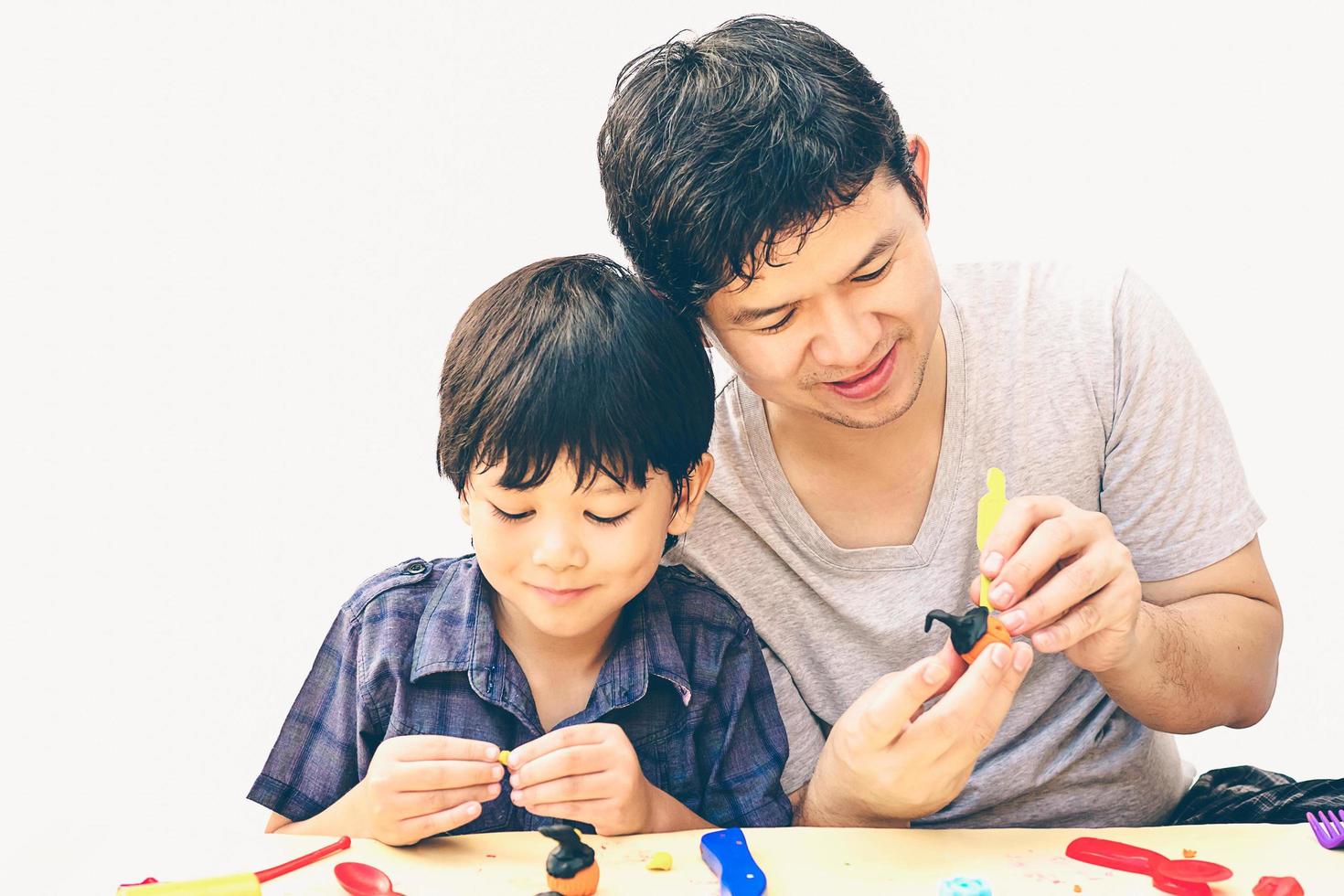 Vintage style photo of father is playing Halloween clay with his son