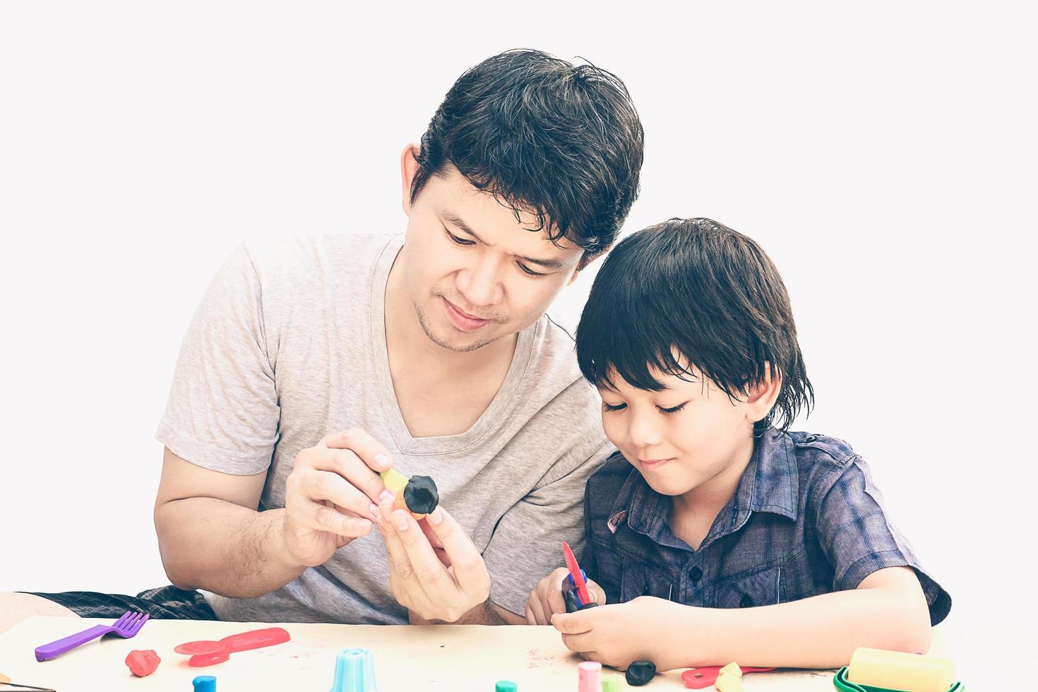 Vintage style photo of father is playing Halloween clay with his son