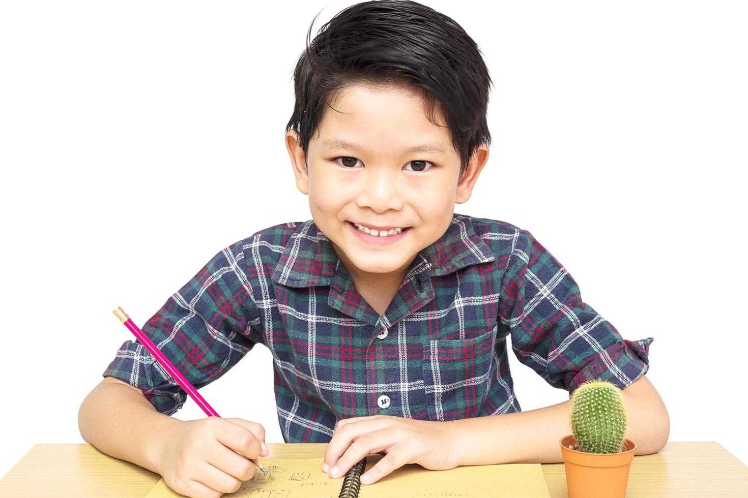 A boy is happily doing homework isolated on white background photo