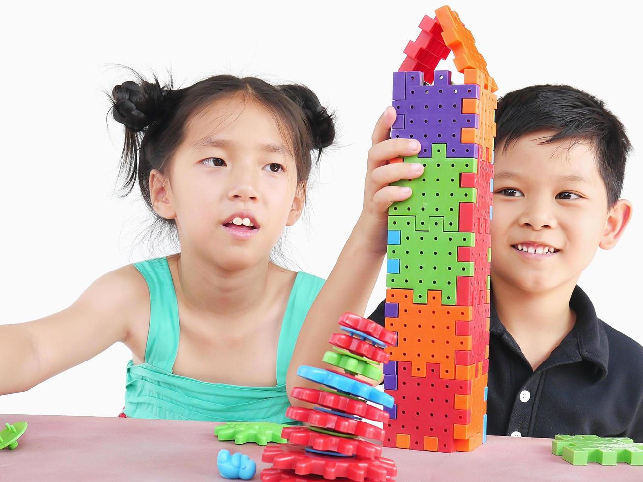 Asian children are playing puzzle plastic block creative game to practice their physical and mental skill photo