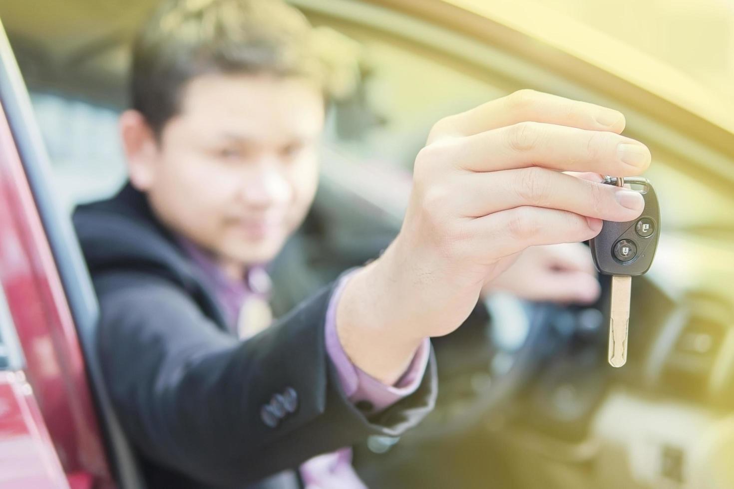 el hombre le está dando la llave de un auto a alguien foto