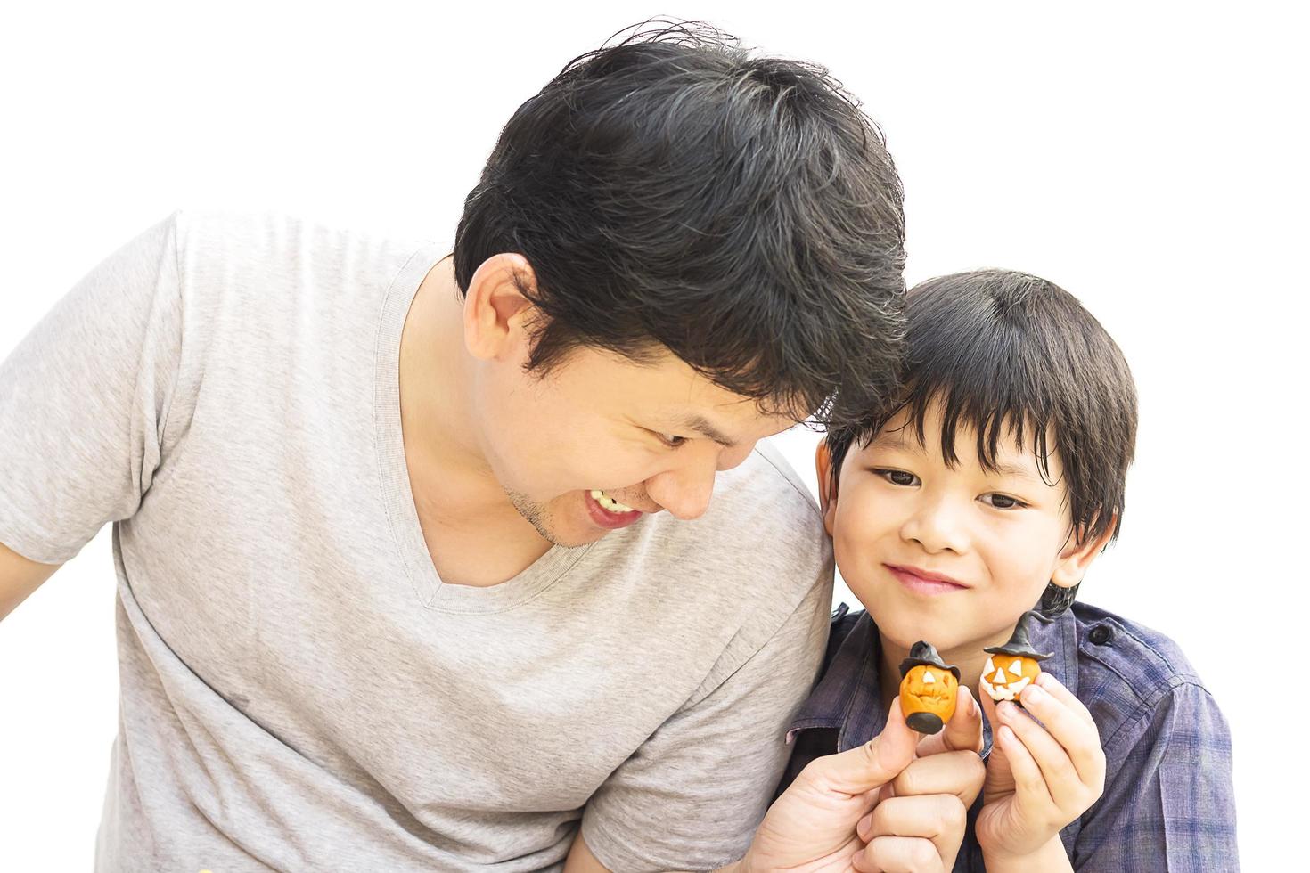 Father is playing Halloween clay with his son over white background photo