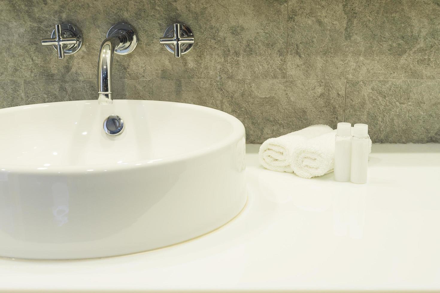 Bath room sink with white cleaning set in a hotel photo