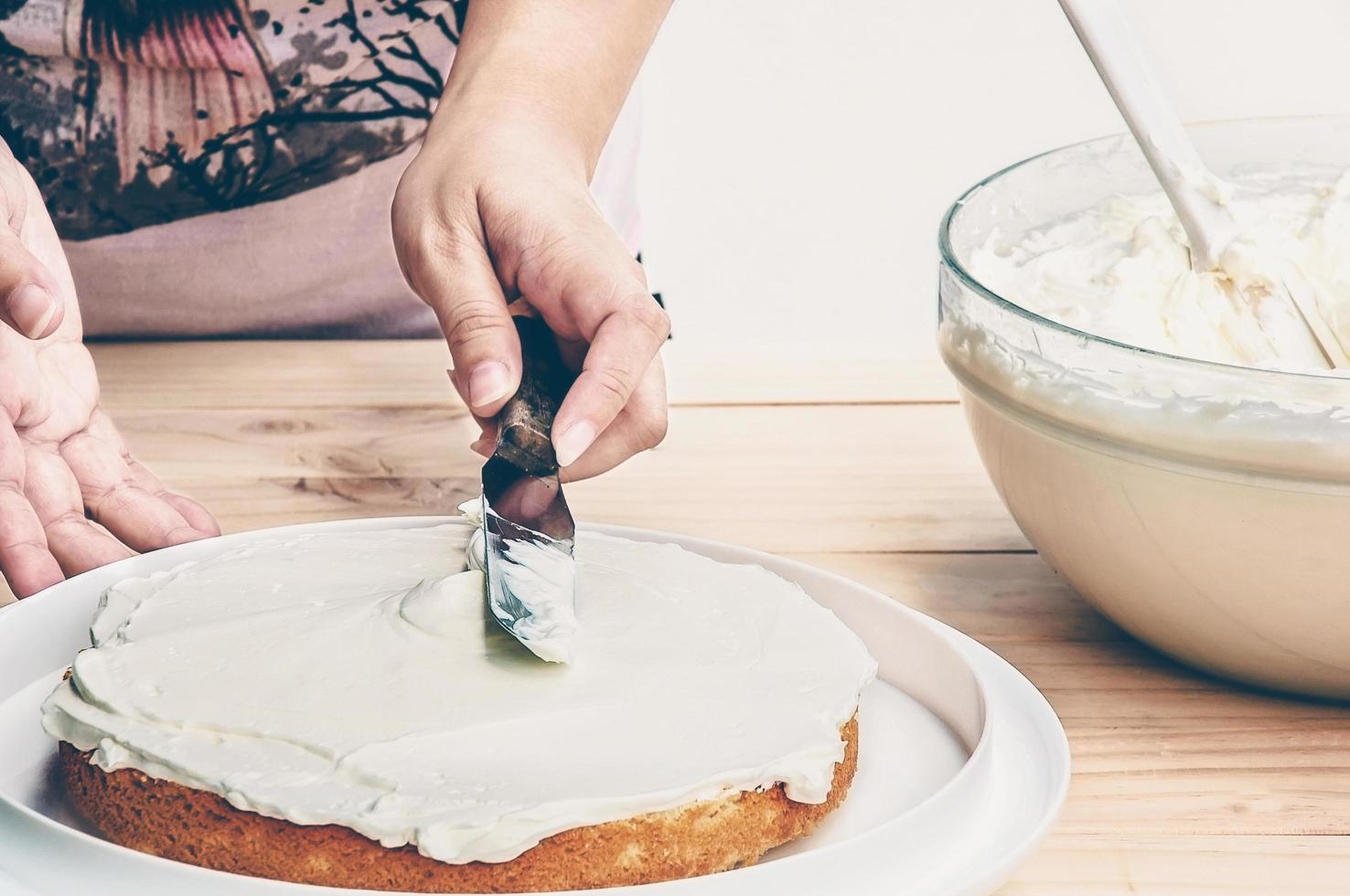 Putting butter  cream cake by hand using spatula photo