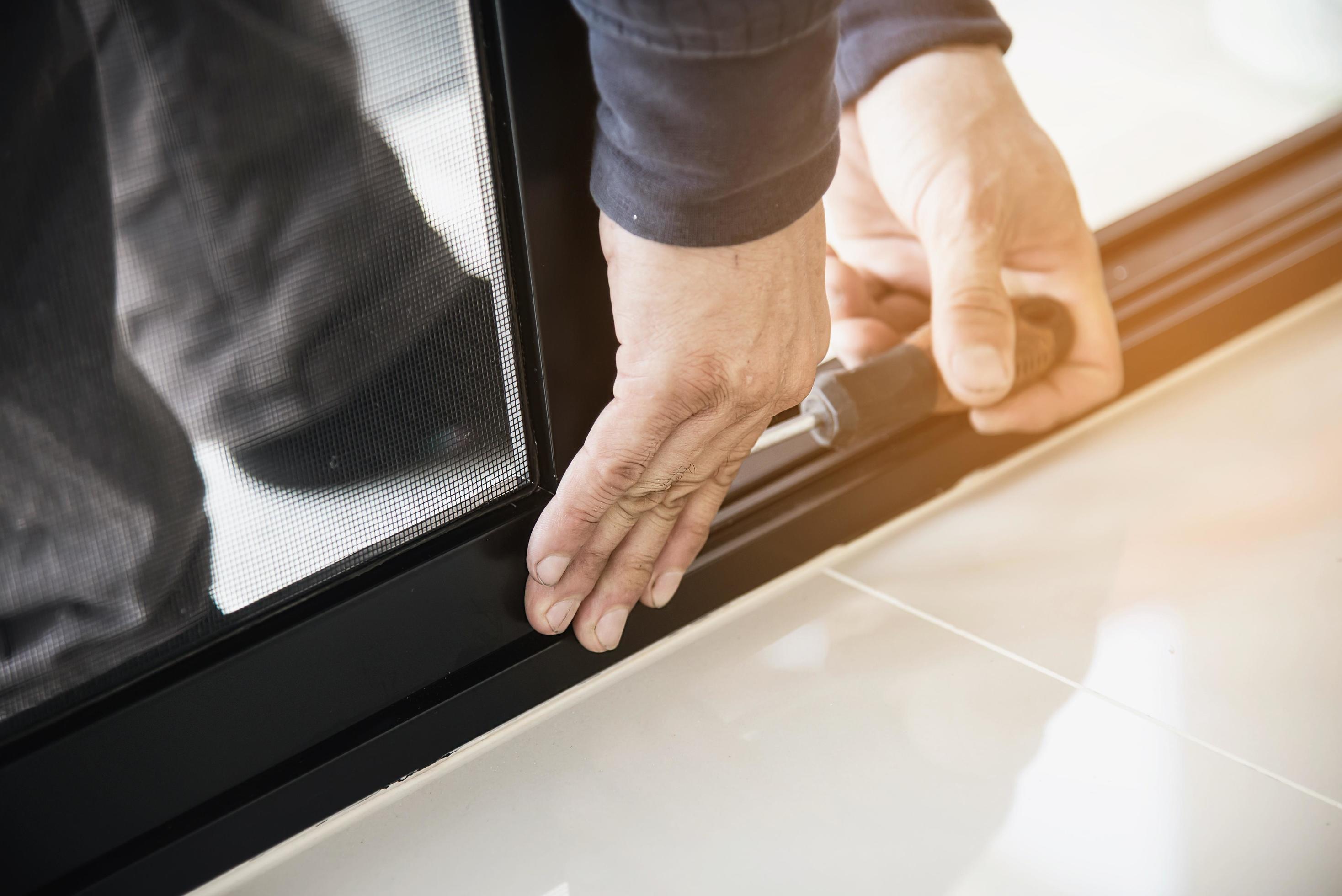 Man doing aluminum frame with glasses and wire screen door and window