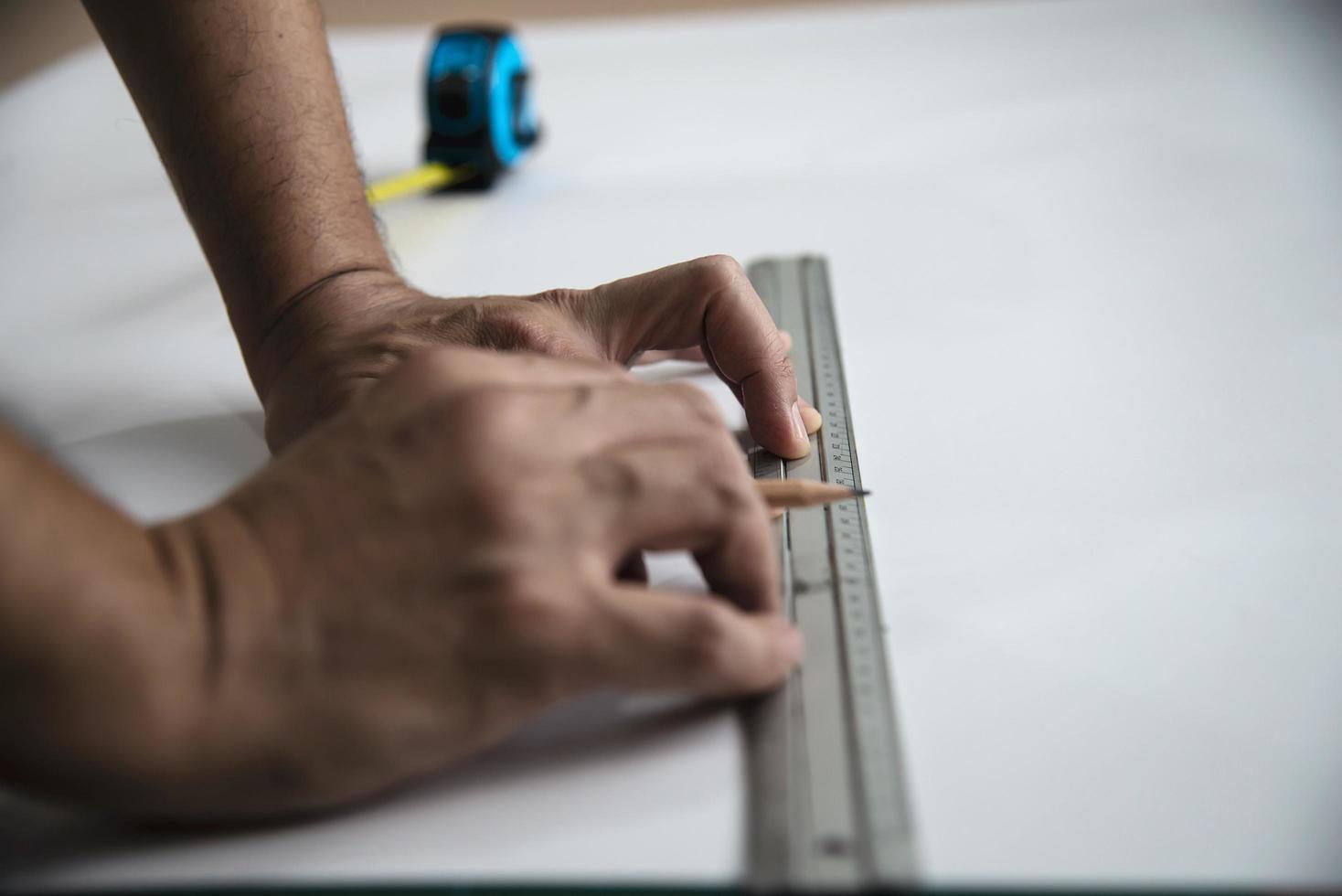 Man using measure hand tool doing wallpaper cutting work in home construction site, people with hand tool object concept photo