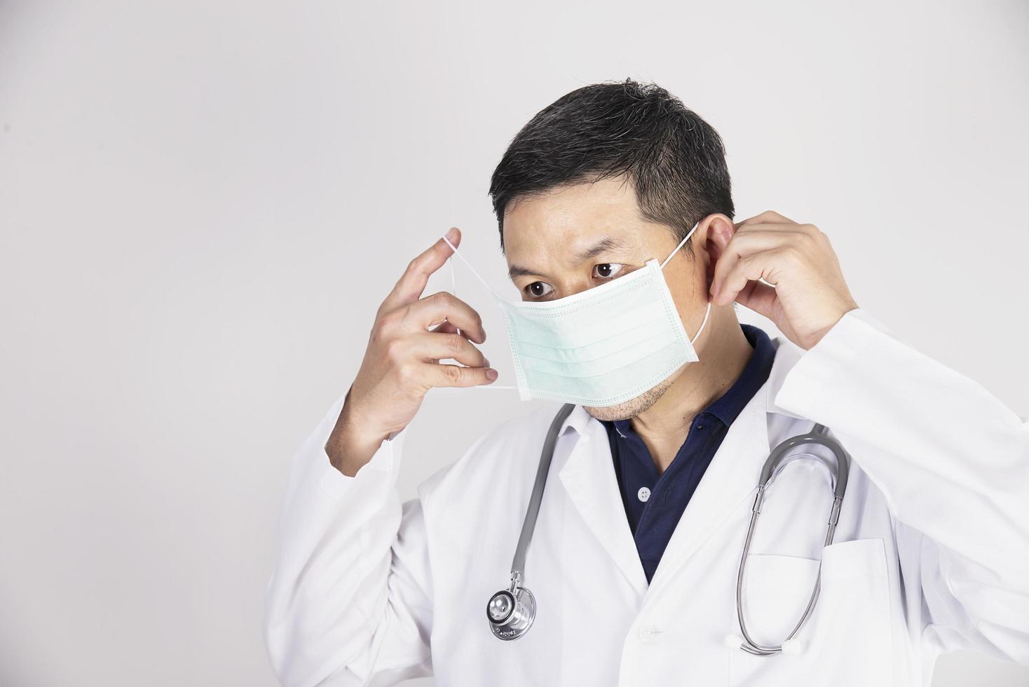 Asian doctor is wearing mask for protecting Covid-19 virus - medical people working concept photo