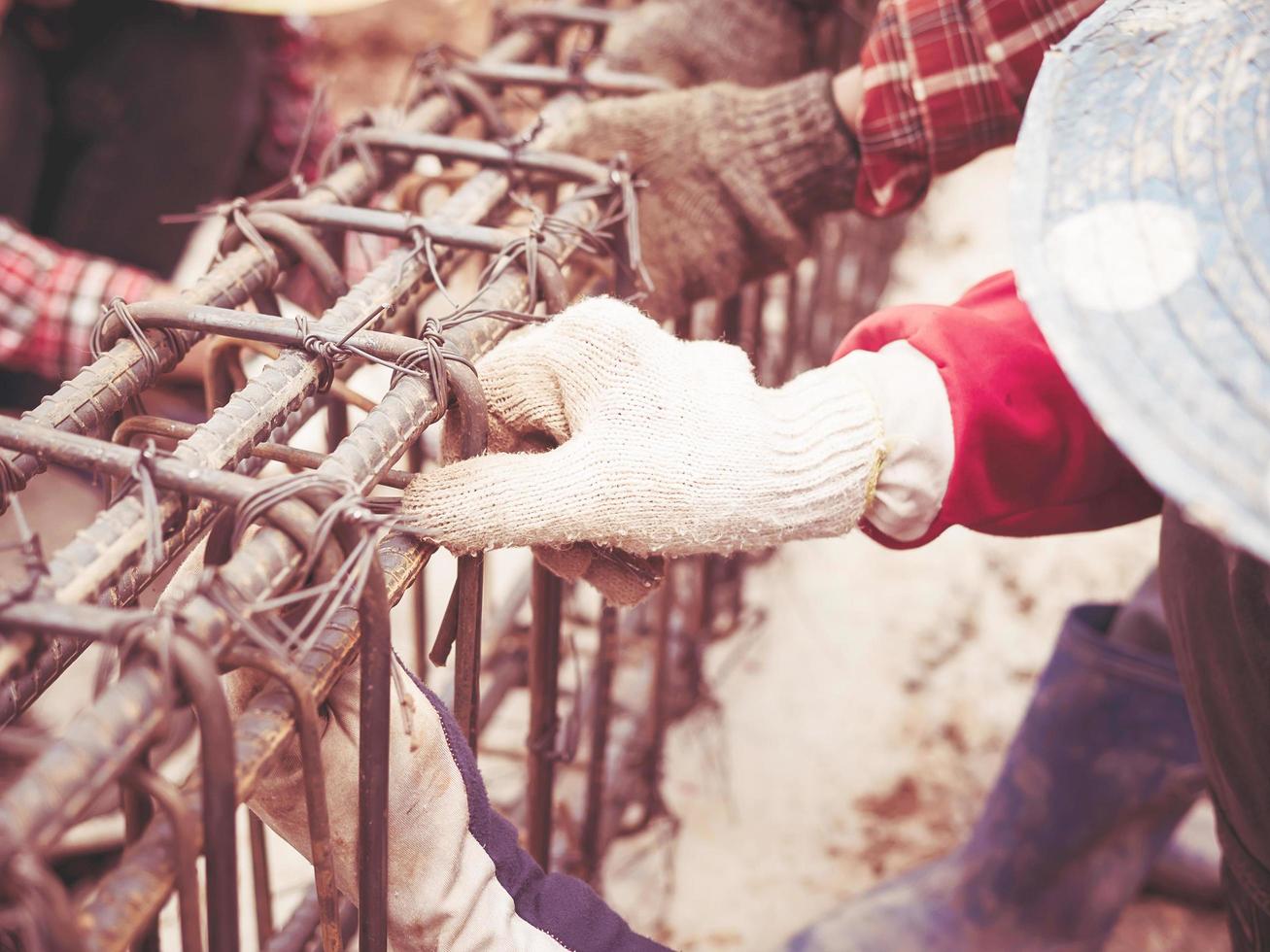 foto de estilo vintage de los trabajadores de la construcción están instalando varillas de acero en una viga de hormigón armado