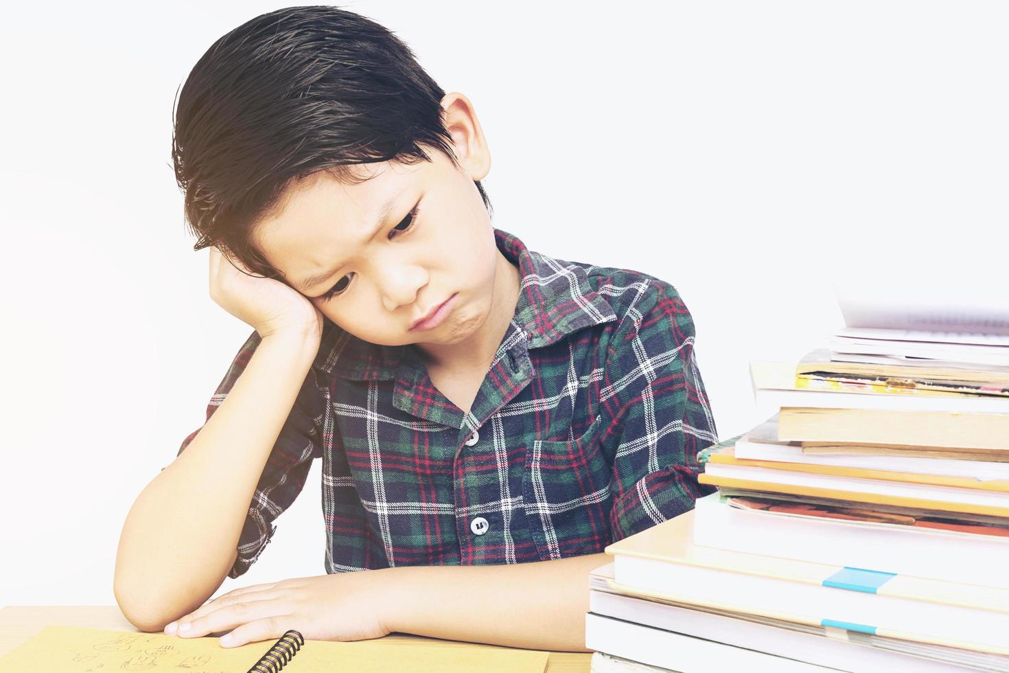 un niño no está feliz haciendo la tarea foto