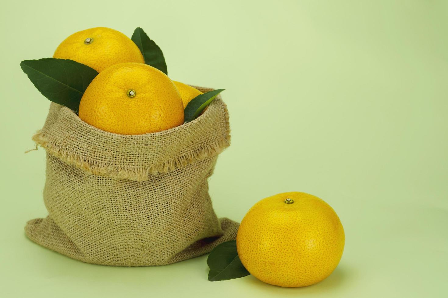 Fresh juicy orange fruit set over light green background - tropical orange fruit for background use photo