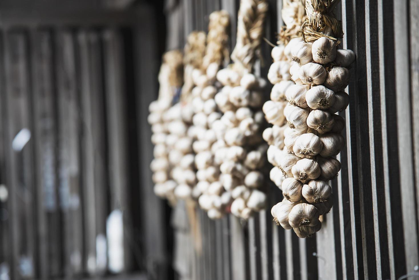 Dry garlic hanging in local kitchen wooden wall - old traditional kitchen Northern Thailand style photo