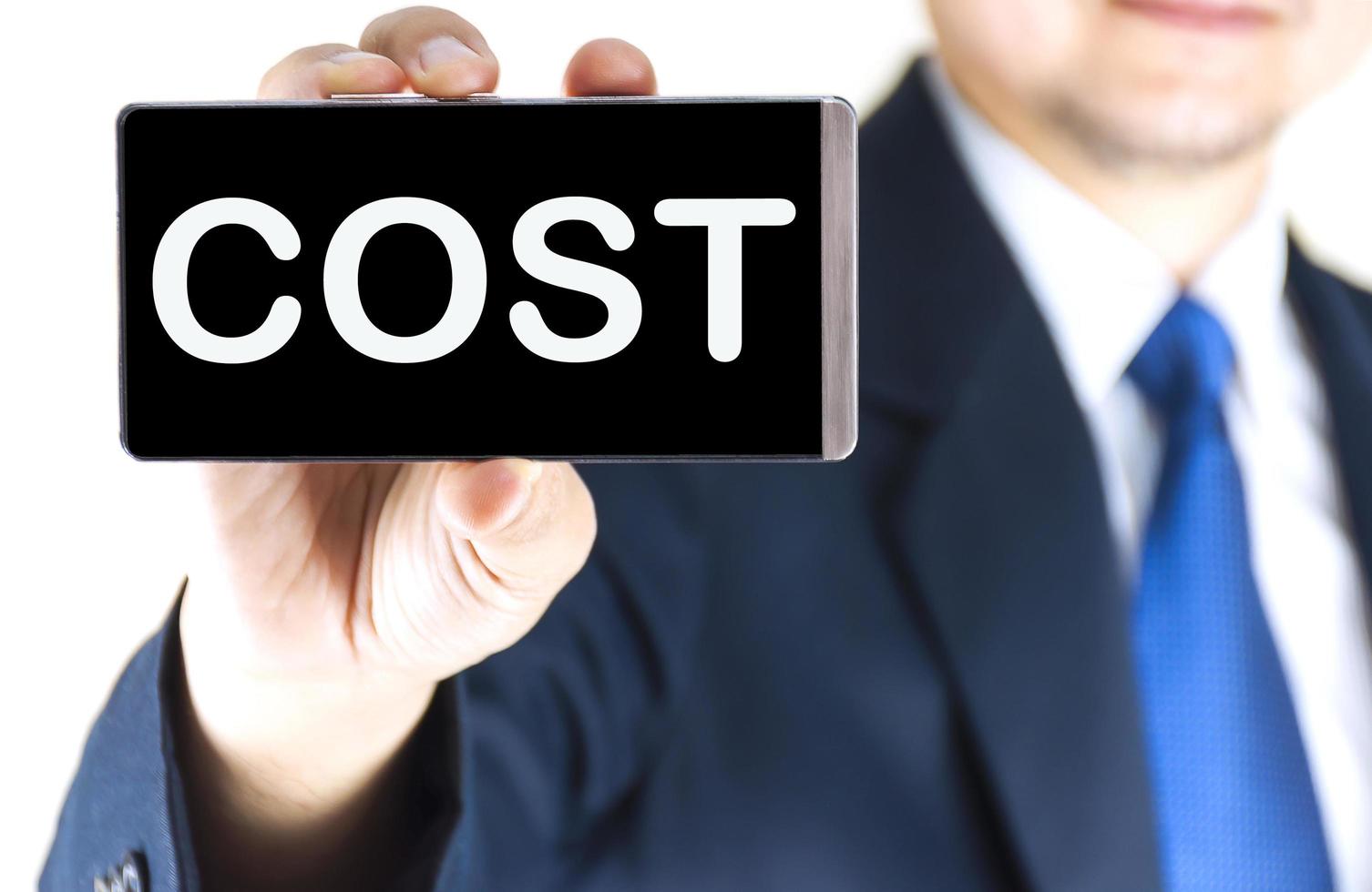 COST, word on mobile phone screen in blurred young businessman hand over white background, business concept photo