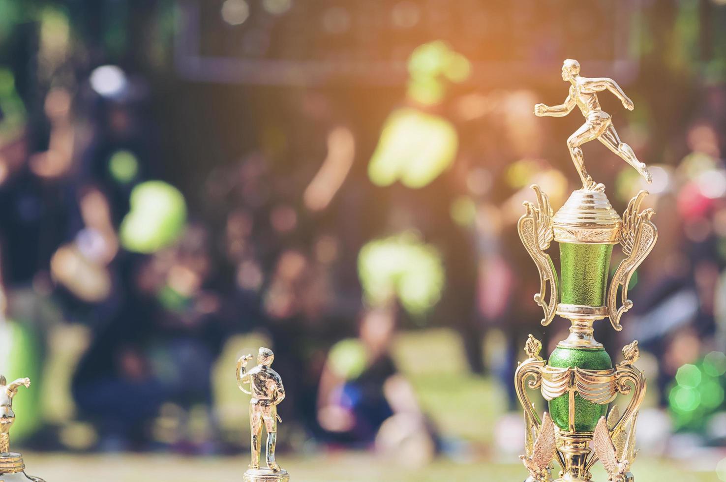 trofeo deportivo sobre desenfoque de gente abarrotada en el festival del día del deporte escolar foto