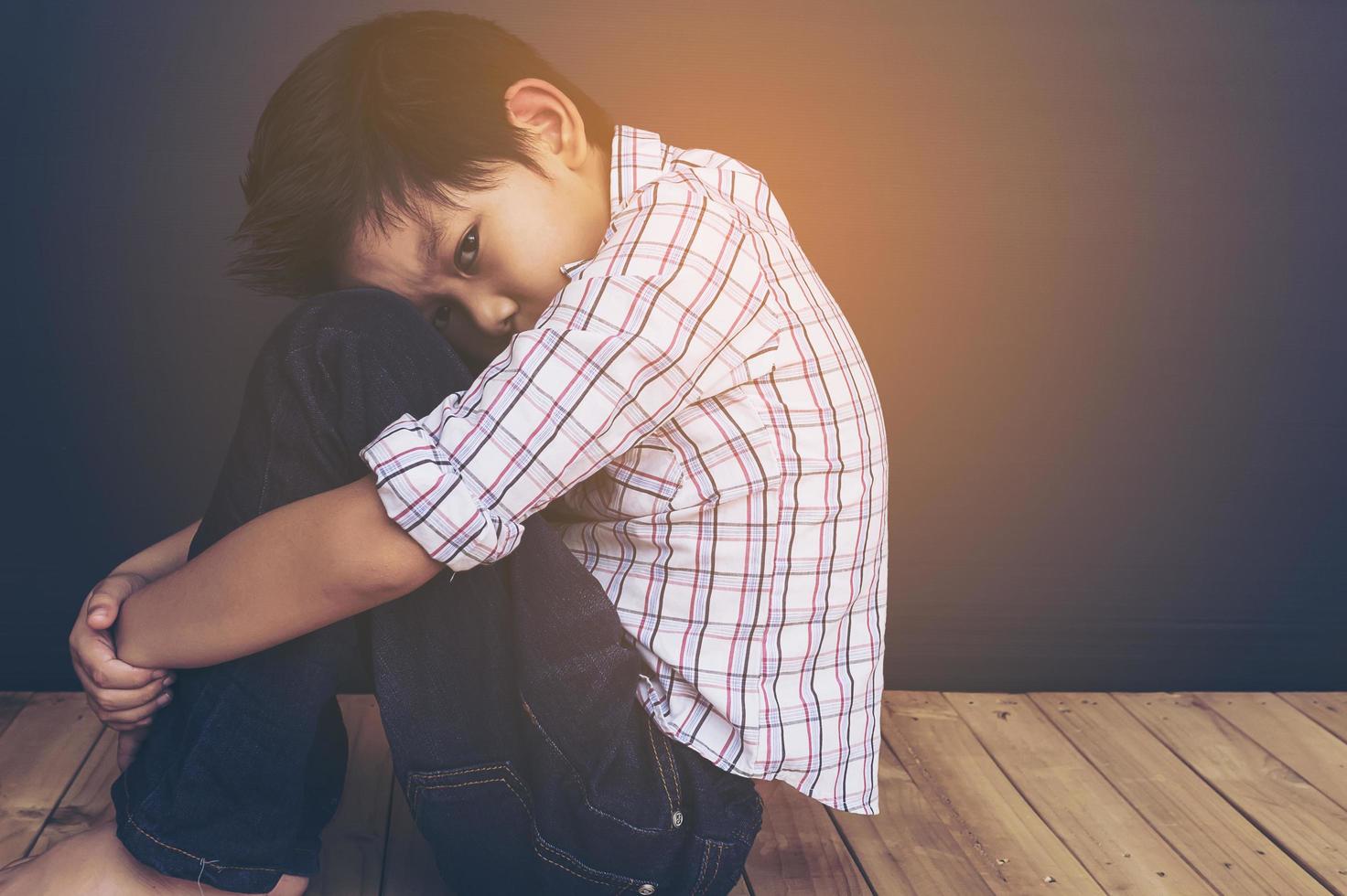 Un niño asiático de 7 años se siente triste foto