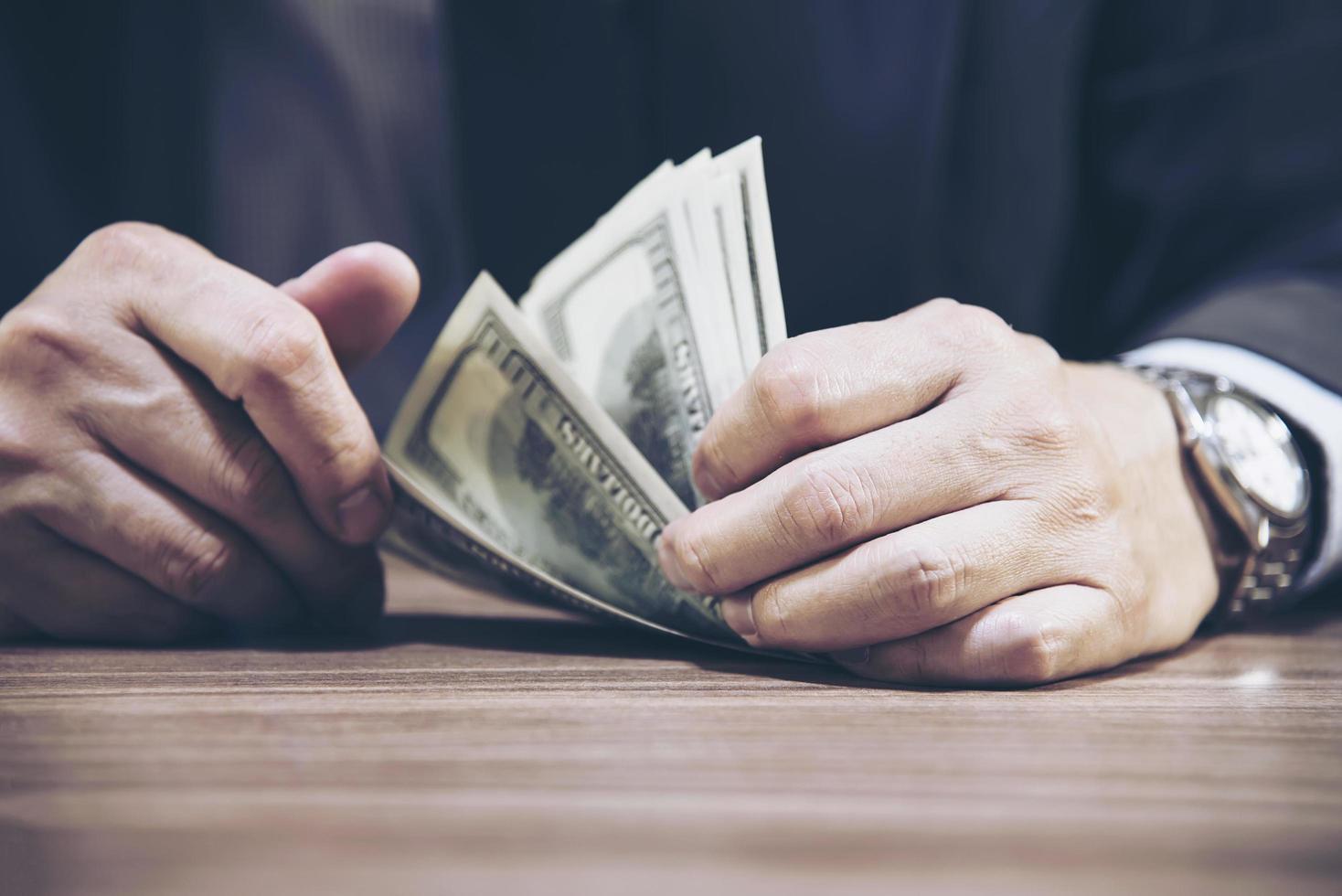 Bank teller man's hands giving dollar banknotes photo