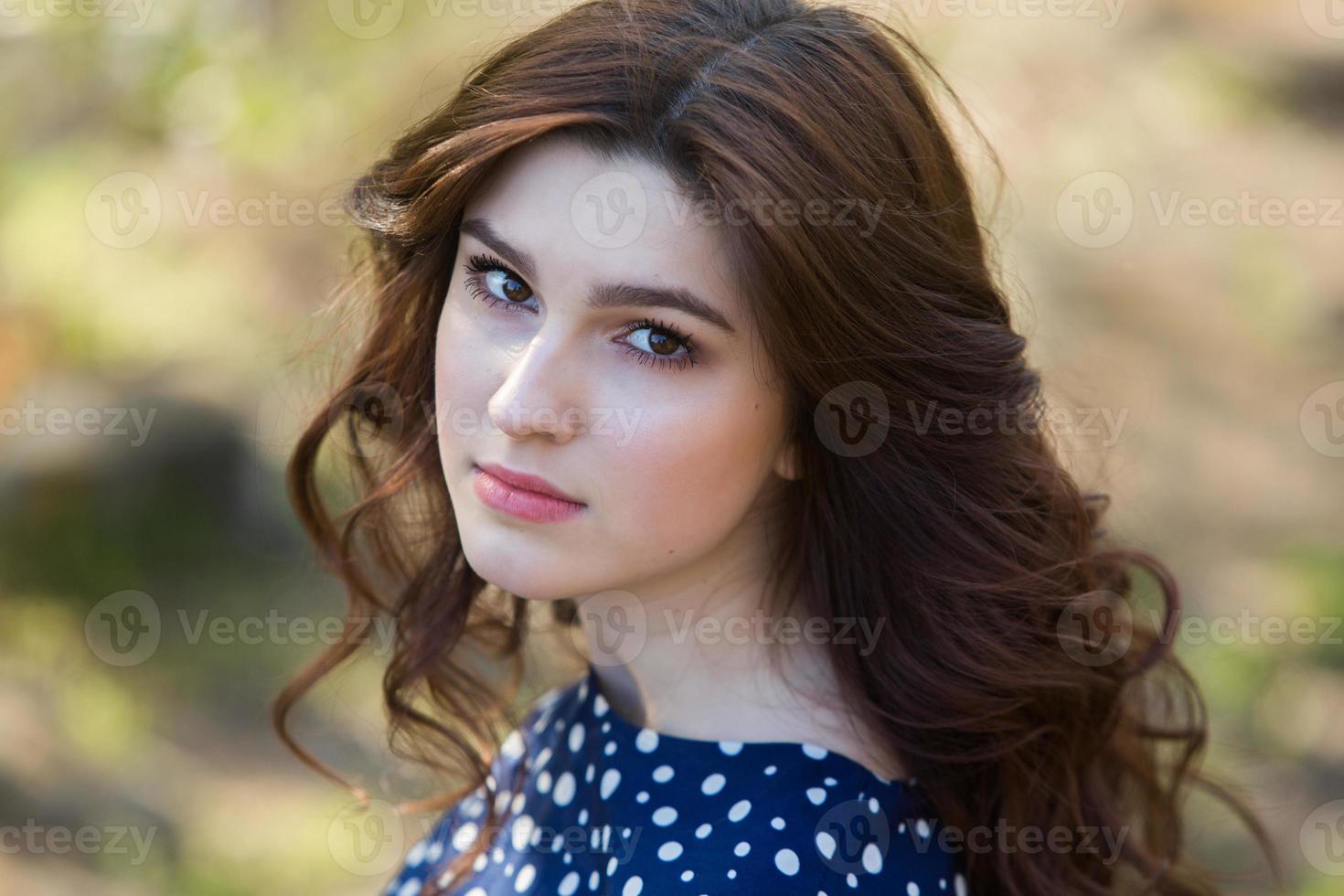 beautiful white european girl with clean skin in the park with flowering trees photo