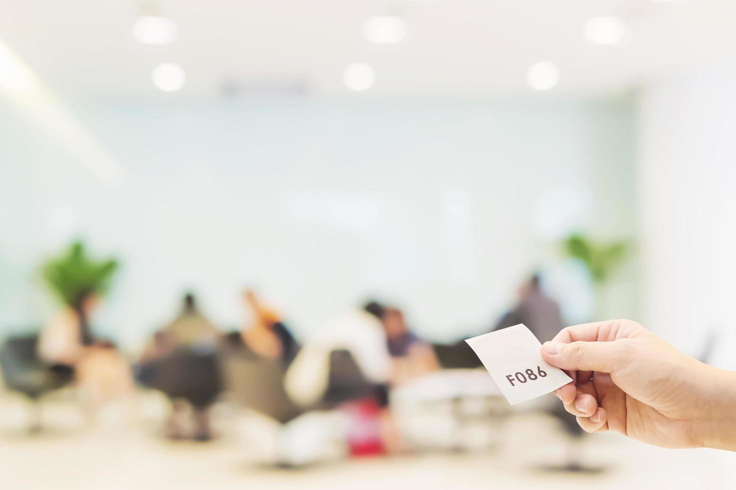 Man is holding queue card while waiting in the modern reception area photo