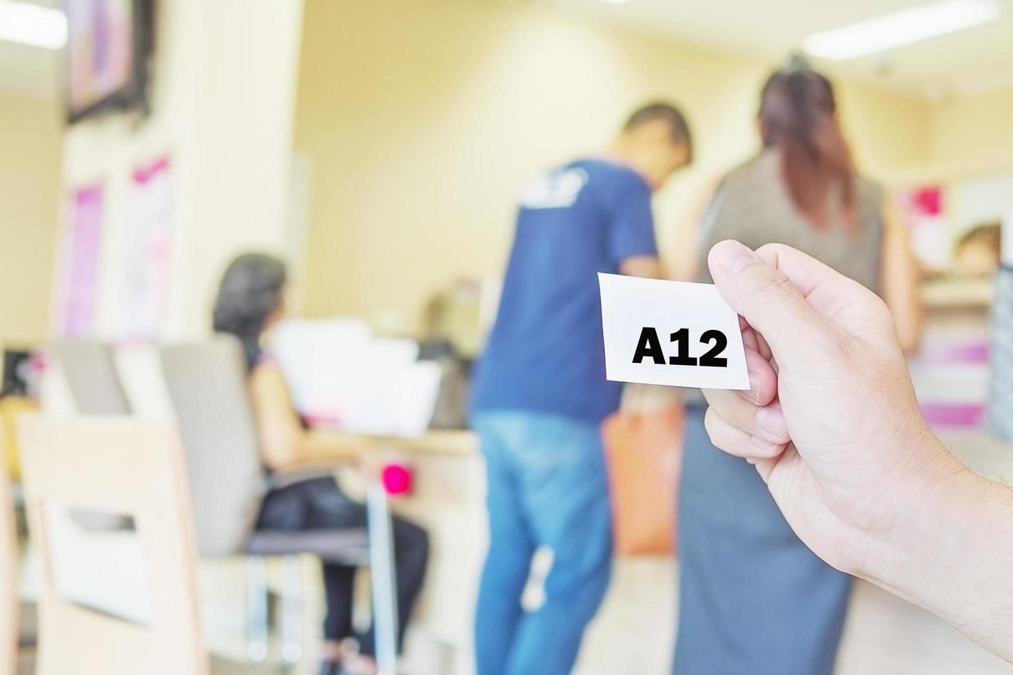 Man is holding queue card while waiting in the modern reception area photo